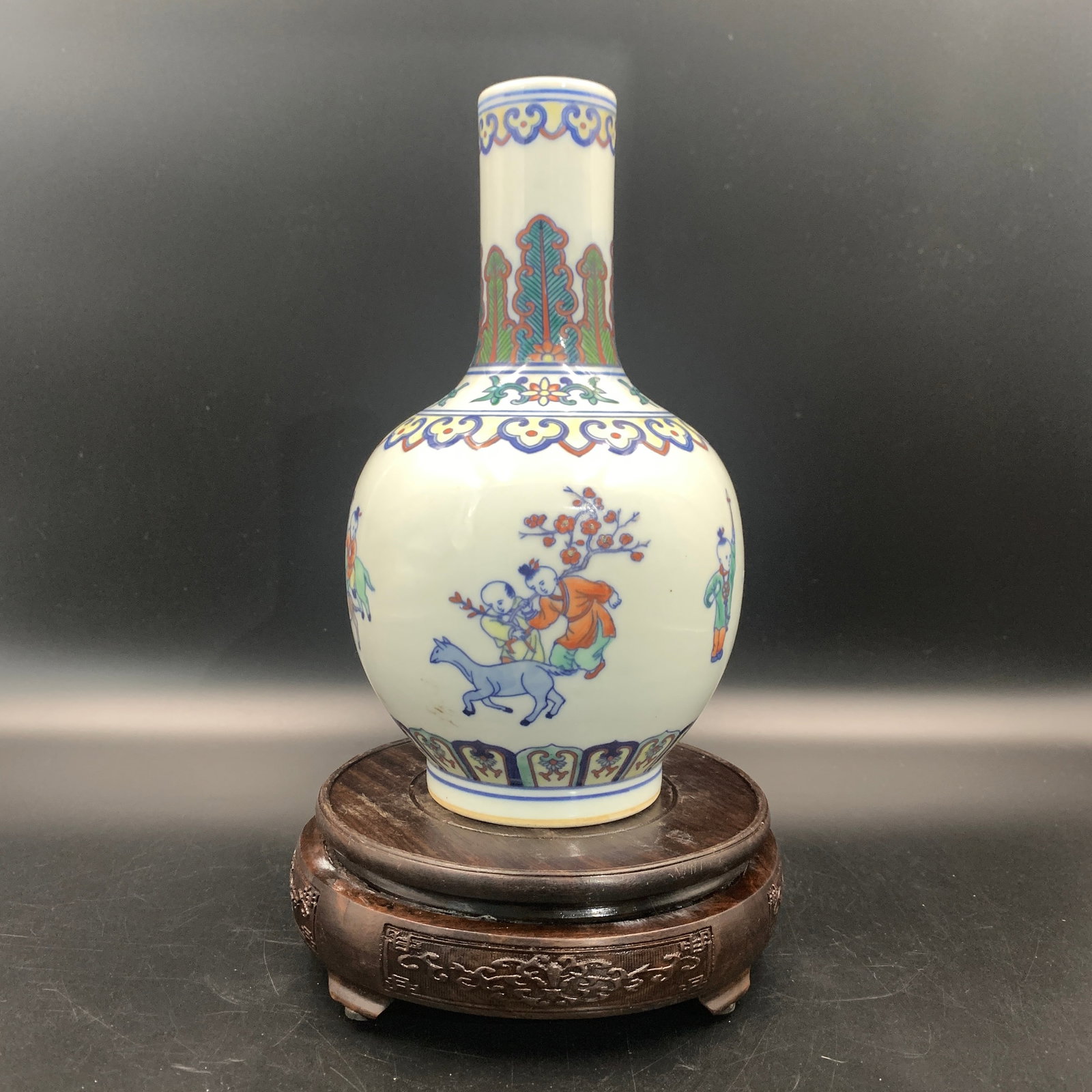 A WUCAI PORCELAIN BOTTLE VASE PAINTED WITH BOYS AT PLAY