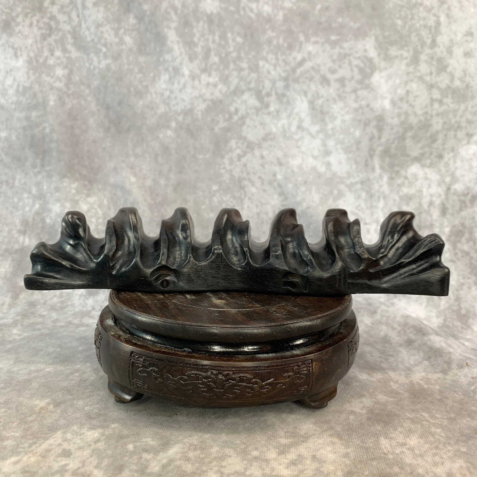 A CARVED DARK HARDWOOD MULTI-PEAK PEN REST