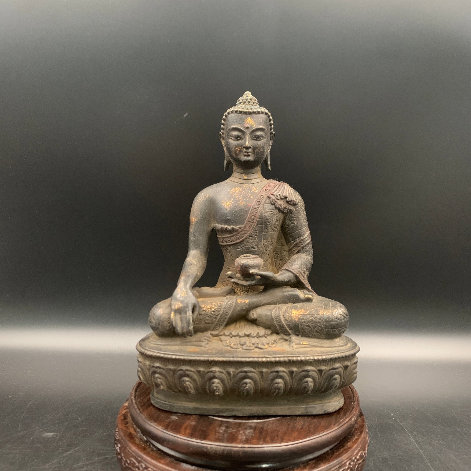 A GILT AND COLD-PAINTED BRONZE FIGURE OF SHAKYAMUNI BUDDHA: 19th Century; Long: 5.5 inch; Width: 3.4 inch; High: 8 inch; Wooden base for diplay only