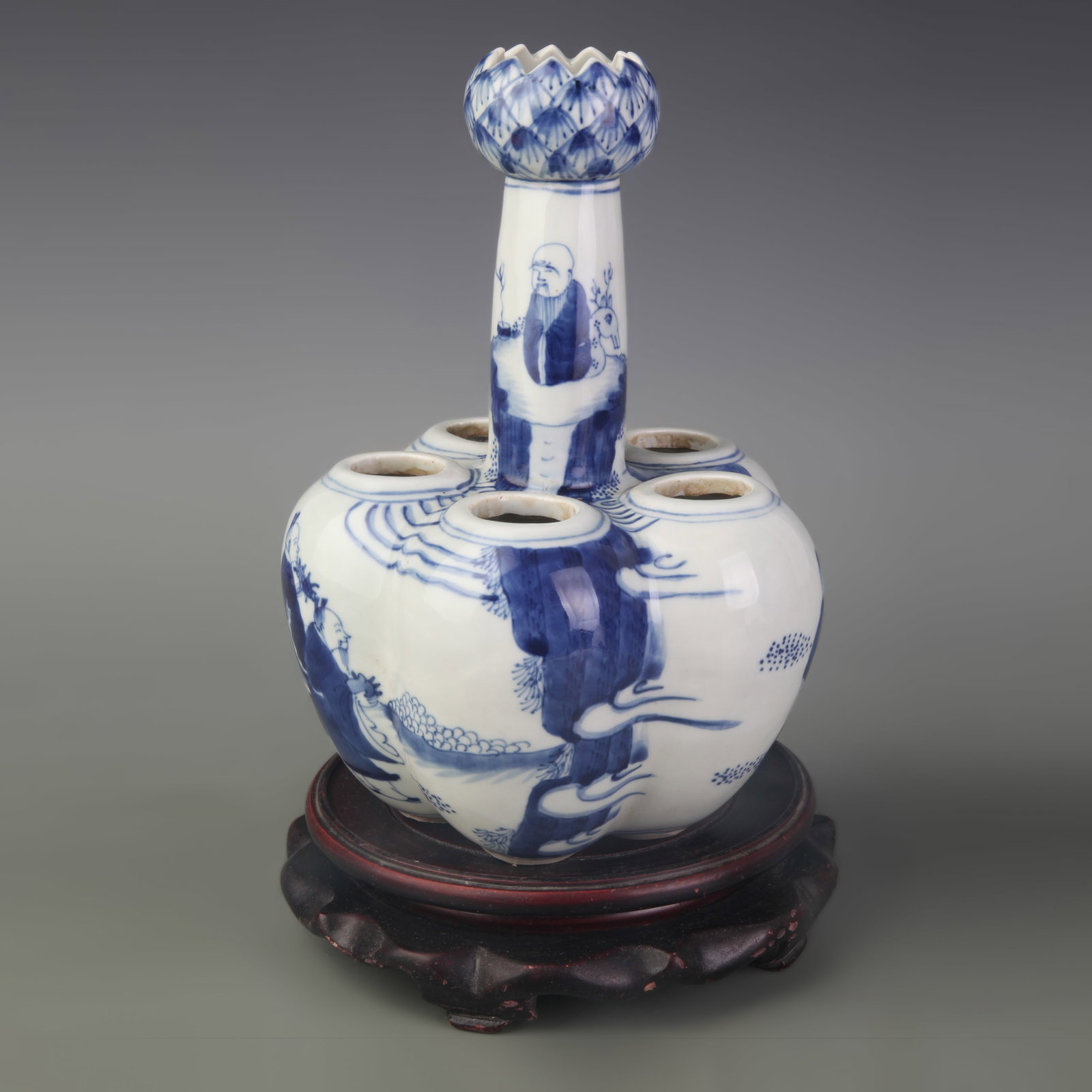 A BLUE AND WHITE FIGURAL SIX-HOLE VASE: Qing Dynasty Kang Xi Period; Width: 6.1 inch; High: 9.1 inch; Wooden base for diplay only