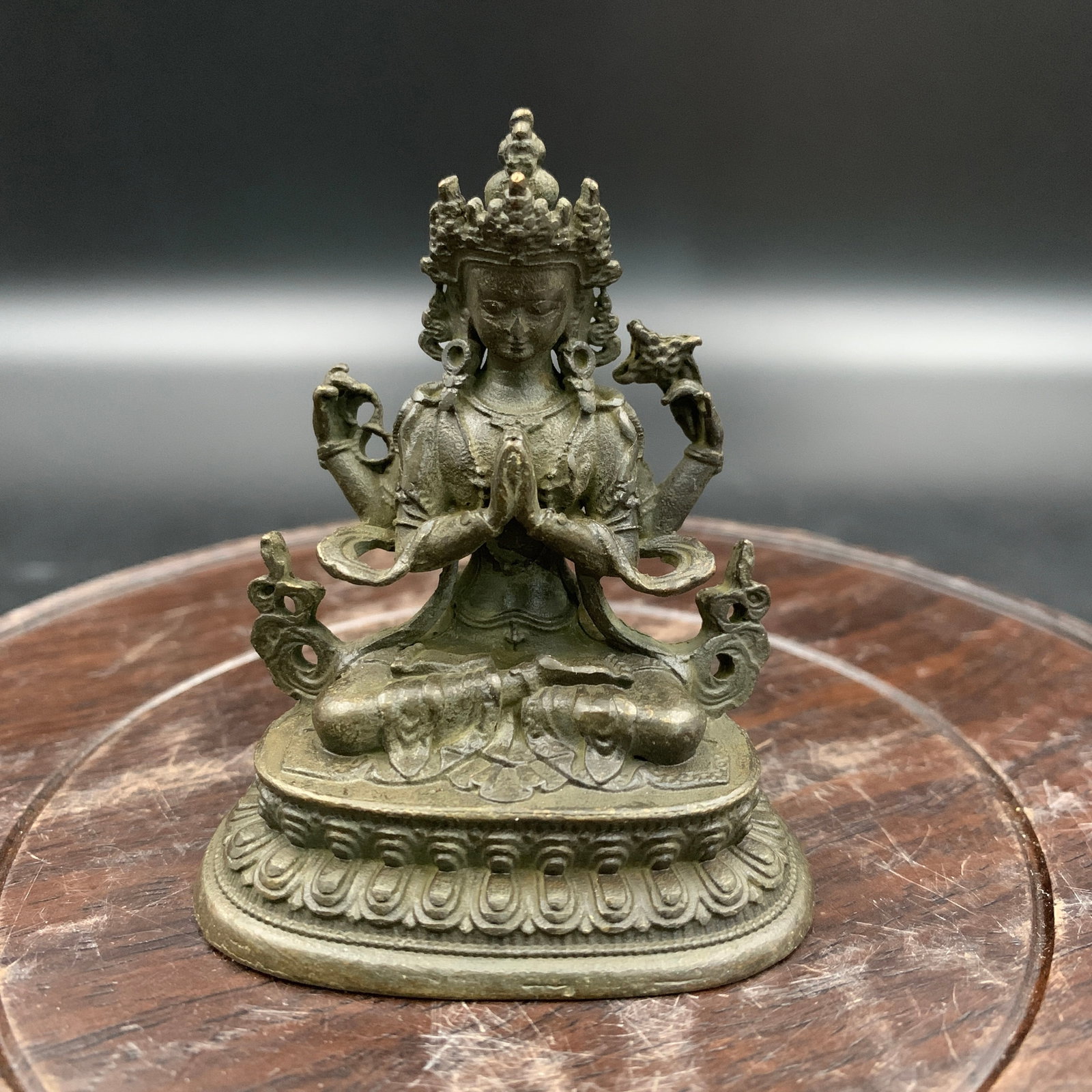 A SMALL BRONZE FOUR-ARMED AVALOKITESHVARA STATUE: Qing Dynasty; Long: 2.1 inch; Width: 1.5 inch; High: 2.4 inch; Wooden base for diplay only