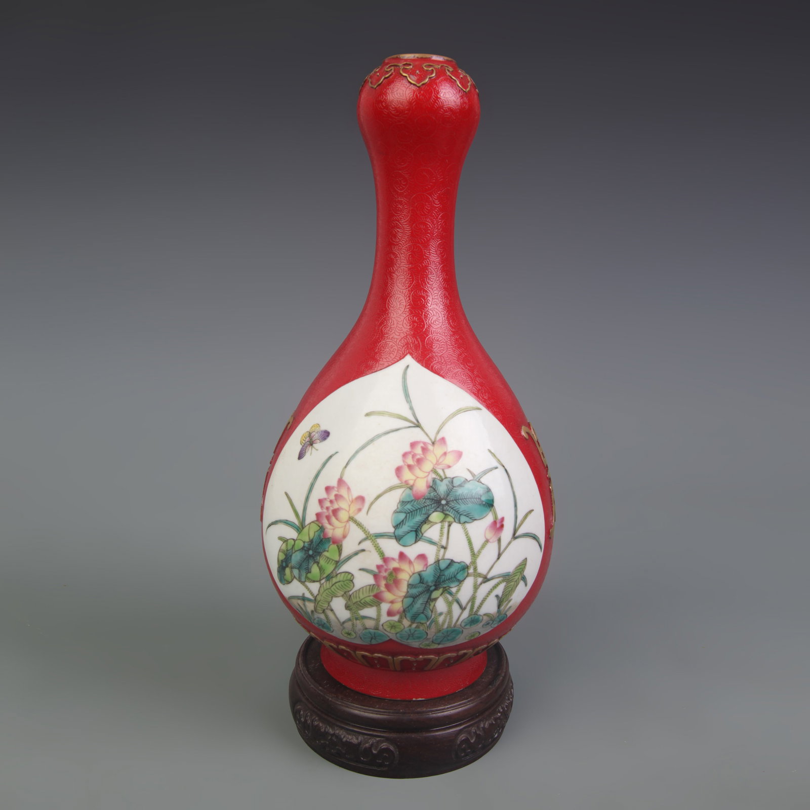 A FAMILLE-ROSE RED-GROUND PANELLED FLORAL GARLIC-NECK VASE