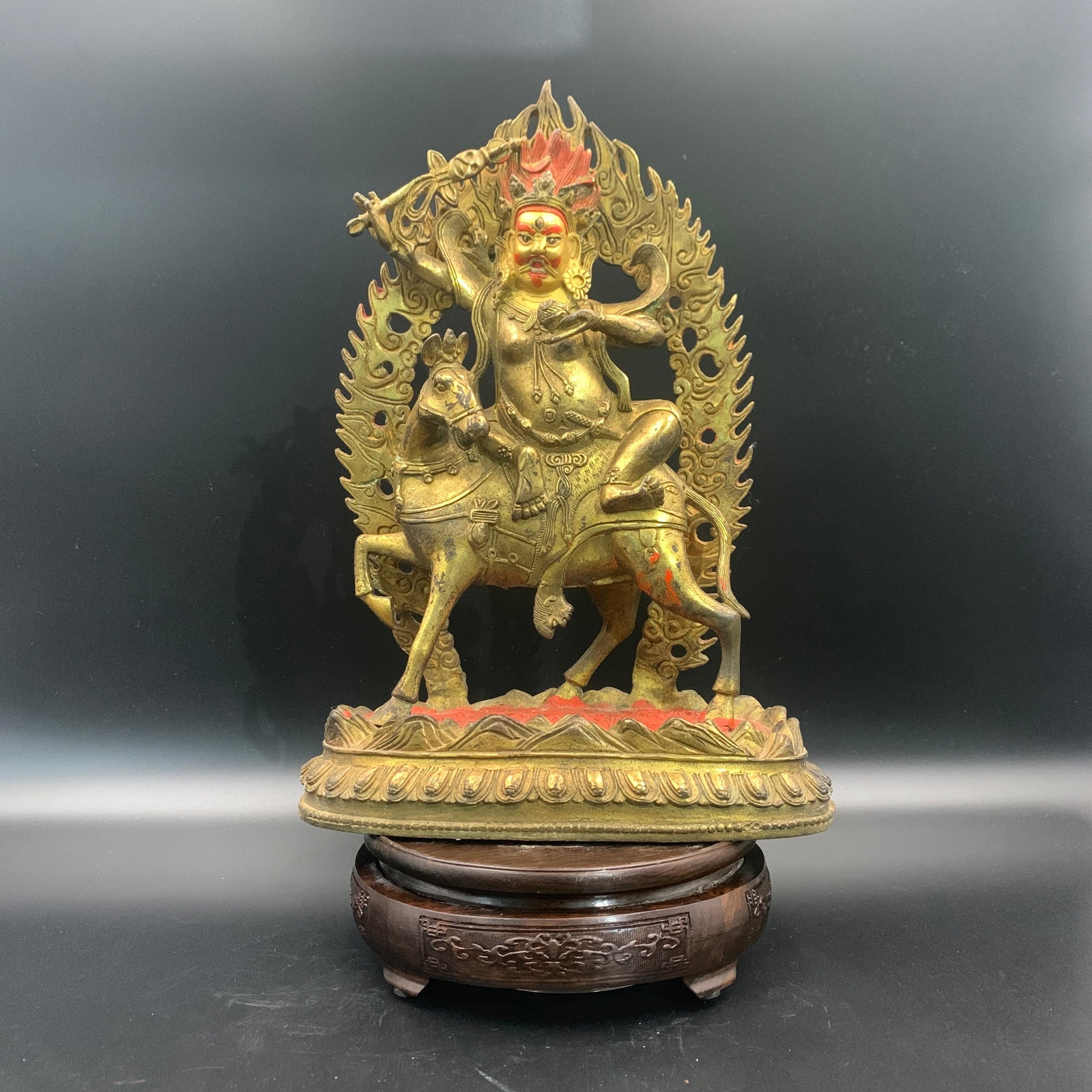 RARE TIBETAN-STYLE GILT-BRONZE FIGURE OF A WRATHFUL DEITY SEATED ON HORSEBACK
