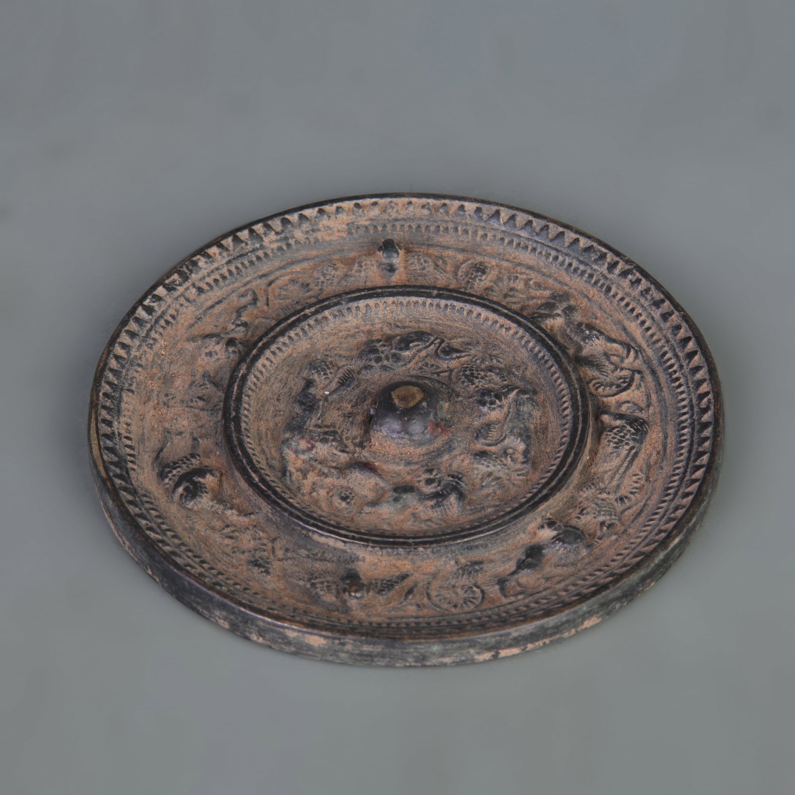 BRONZE MIRROR WITH SEA-CREATURE AND GRAPE DESIGN