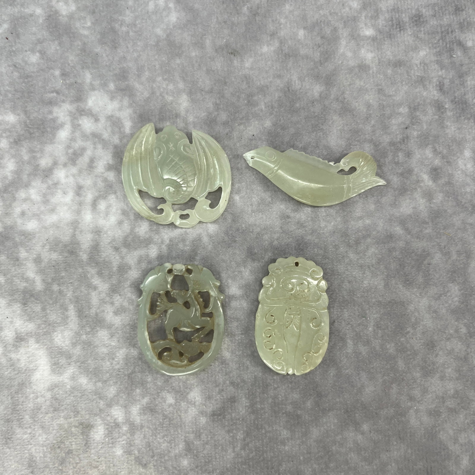 GROUP OF FOUR HAND CARVED HETIAN JADE PENDANT