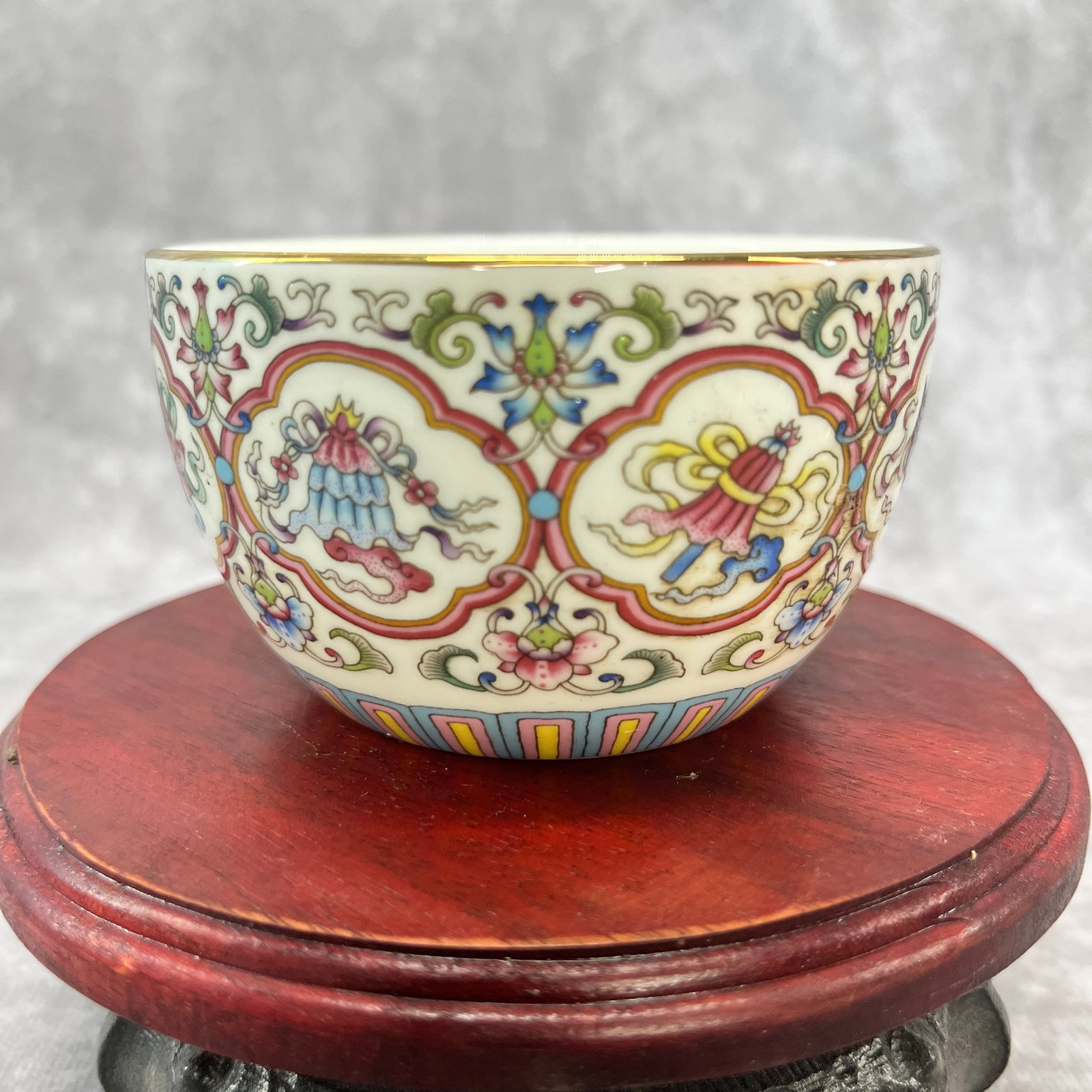A FINE FAMILLE ROSE EIGHT TREASURES PATTERN PORCELAIN TEA CUP: Ming Dynasty Style; High: 2.1 inch; Diameter: 3.5 inch; Wooden base for diplay only