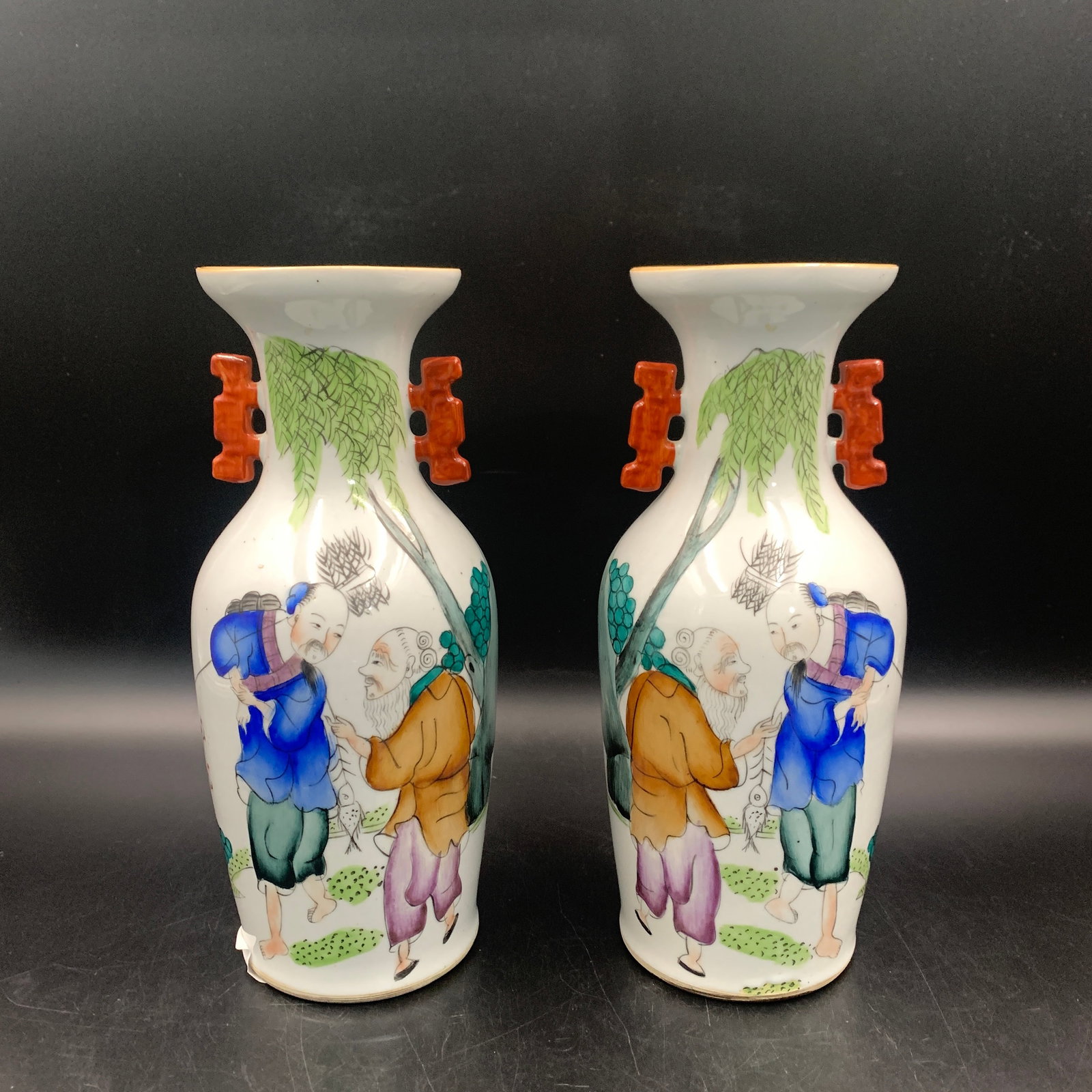 PAIR OF FAMILLE ROSE LANDSCAPE PATTERN VASES WITH IRON-RED HANDLES: Qing Dynasty; High: 10 inch; Diameter: 4.3 inch; Wooden base for diplay only