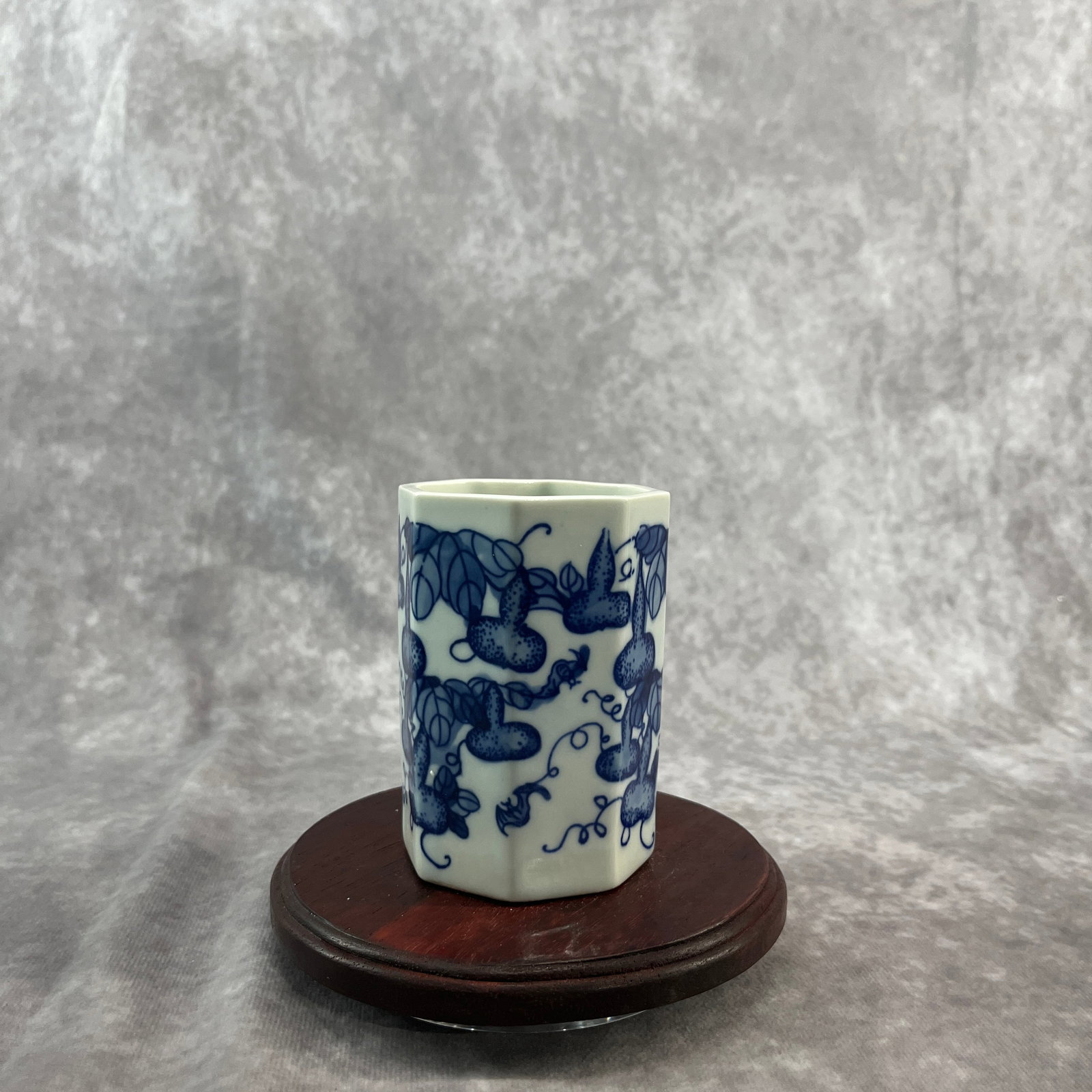 A FINE BLUE AND WHITE OCTAGONAL 'GOURD AND VINE' BRUSH POT, BI TONG: Qing Dynasty; High: 3.7 inch; Diameter: 2.7 inch; Wooden base for diplay only