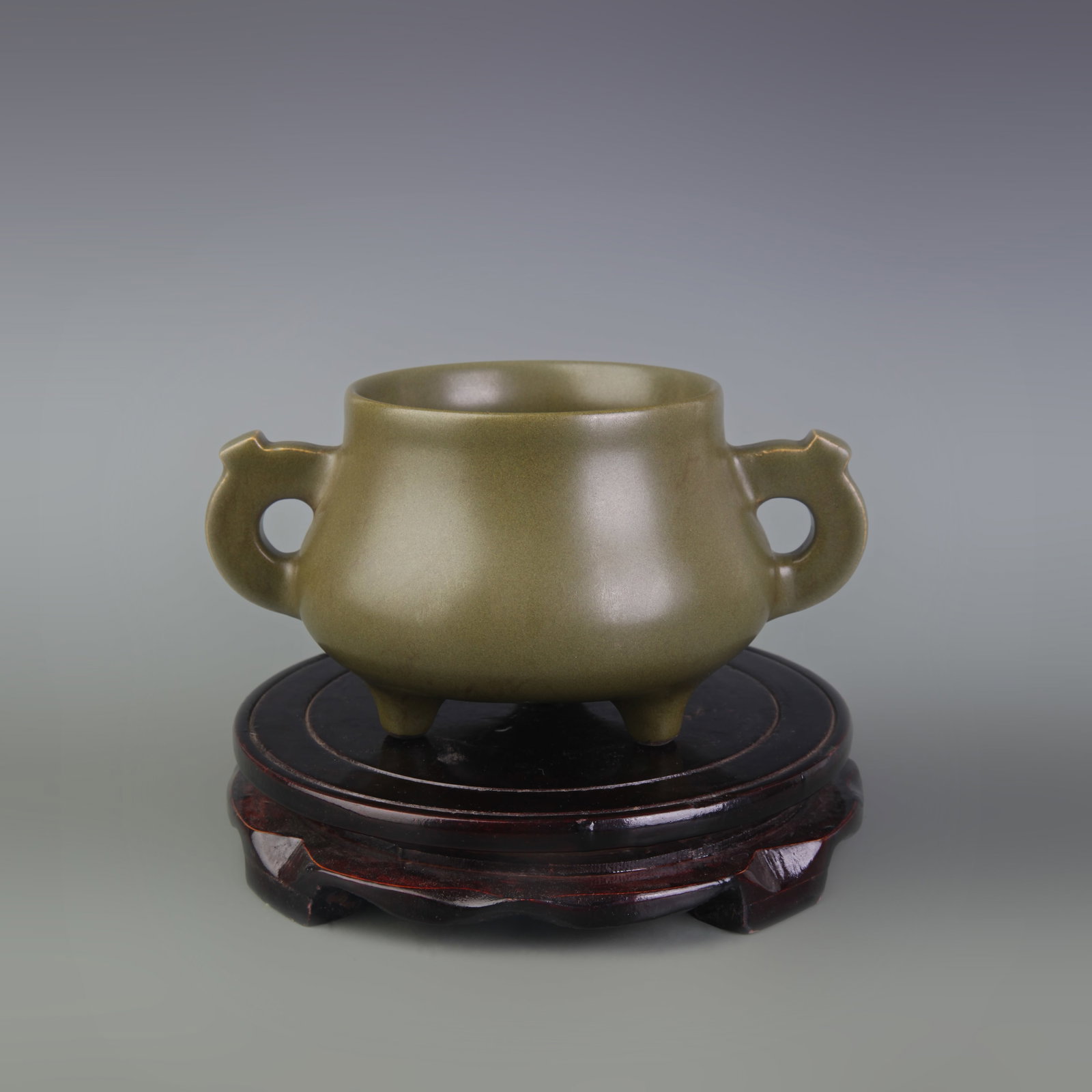 AN EEL-YELLOW GLAZED DOUBLE-HANDLED TRIPOD CENSER: Qing Dynasty Qian Long Period; Diameter: 3.9 inch; High: 3.6 inch; Wooden base for diplay only