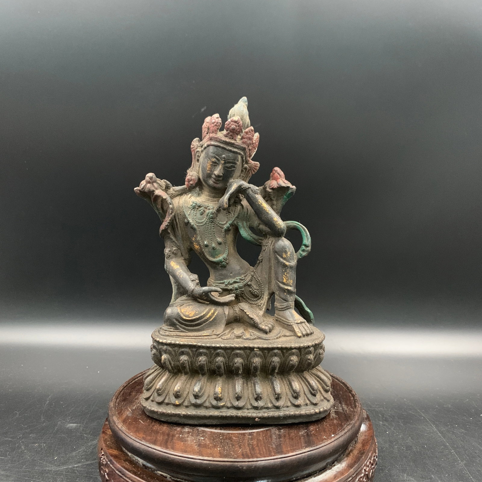 A GILT AND PAINTED BRONZE FIGURE OF A PENSIVE BODHISATTVA, AVALOKITESHVARA (GUANYIN): 20th Century; Long: 4.4 inch; Width: 2.9 inch; High: 7.3 inch; Wooden base for diplay only