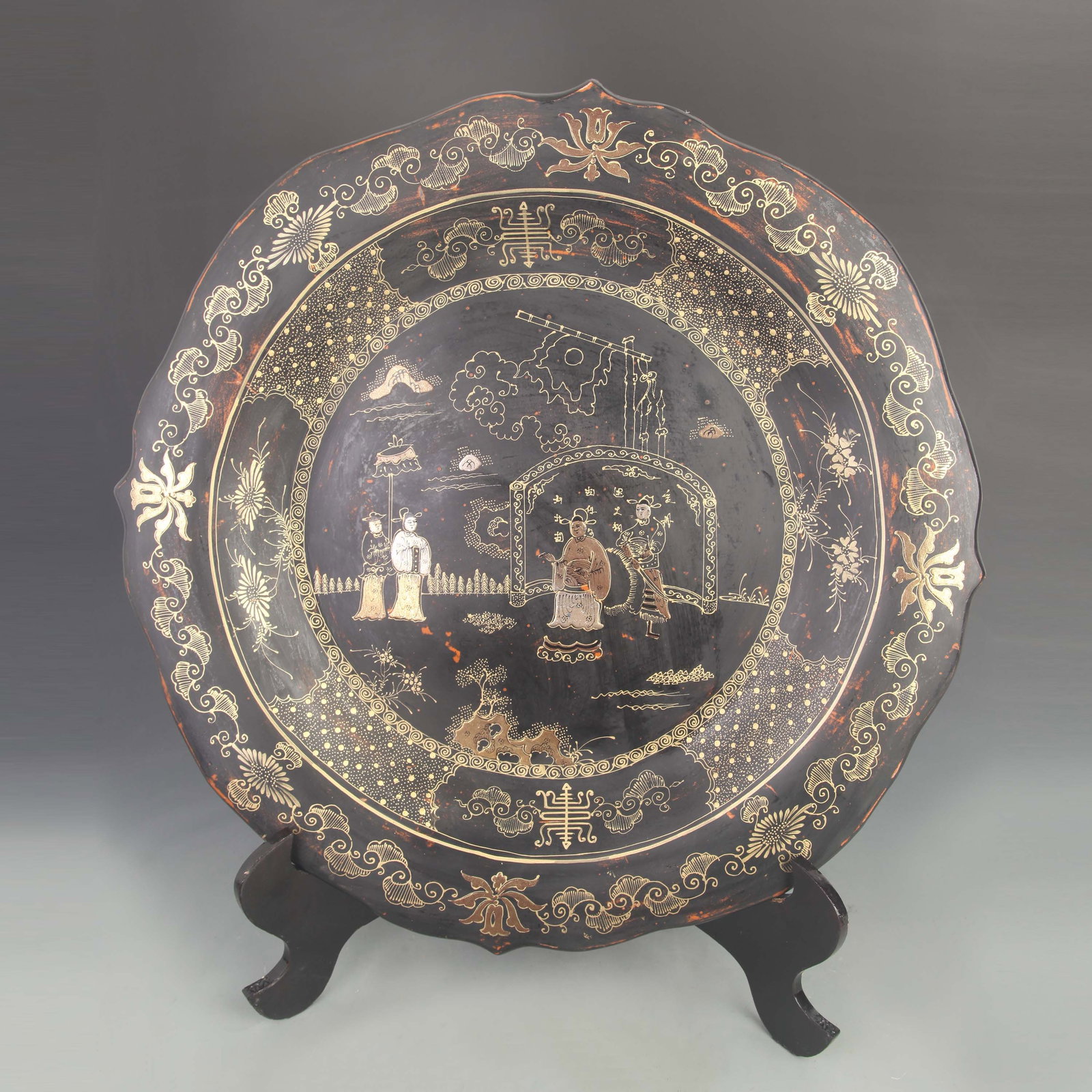 A LARGE GILT-DECORATED LACQUER WOOD DISH WITH FIGURAL NARRATIVE
