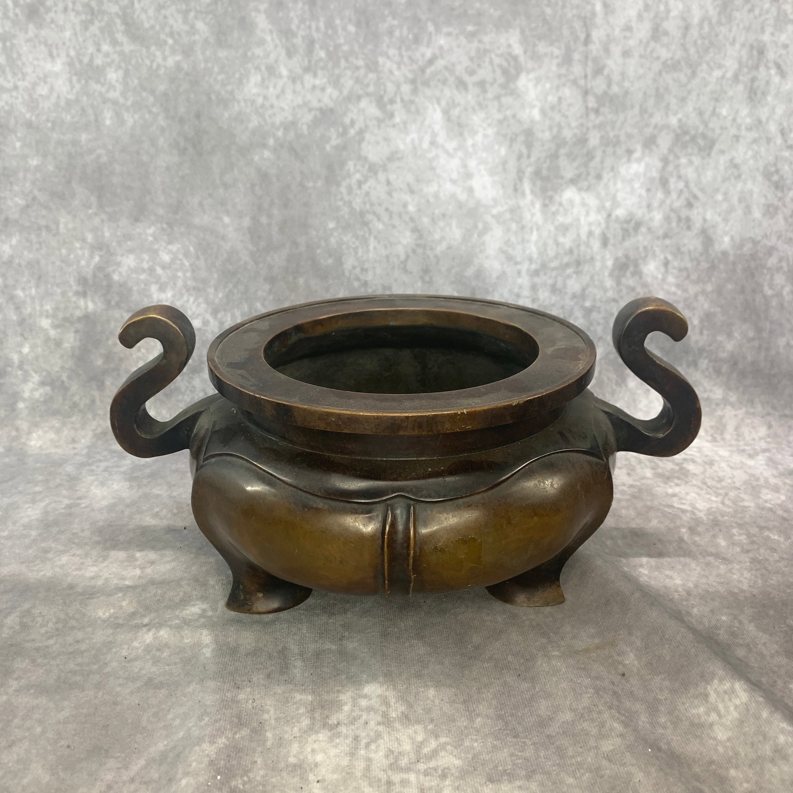 A VERY LARGE BRONZE S-SHAPED HANDLE TRIPOD CENSER: Qing Dynasty; Long: 12.3 inch; Width: 8.9 inch; High: 5.7 inch; Wooden base for diplay only