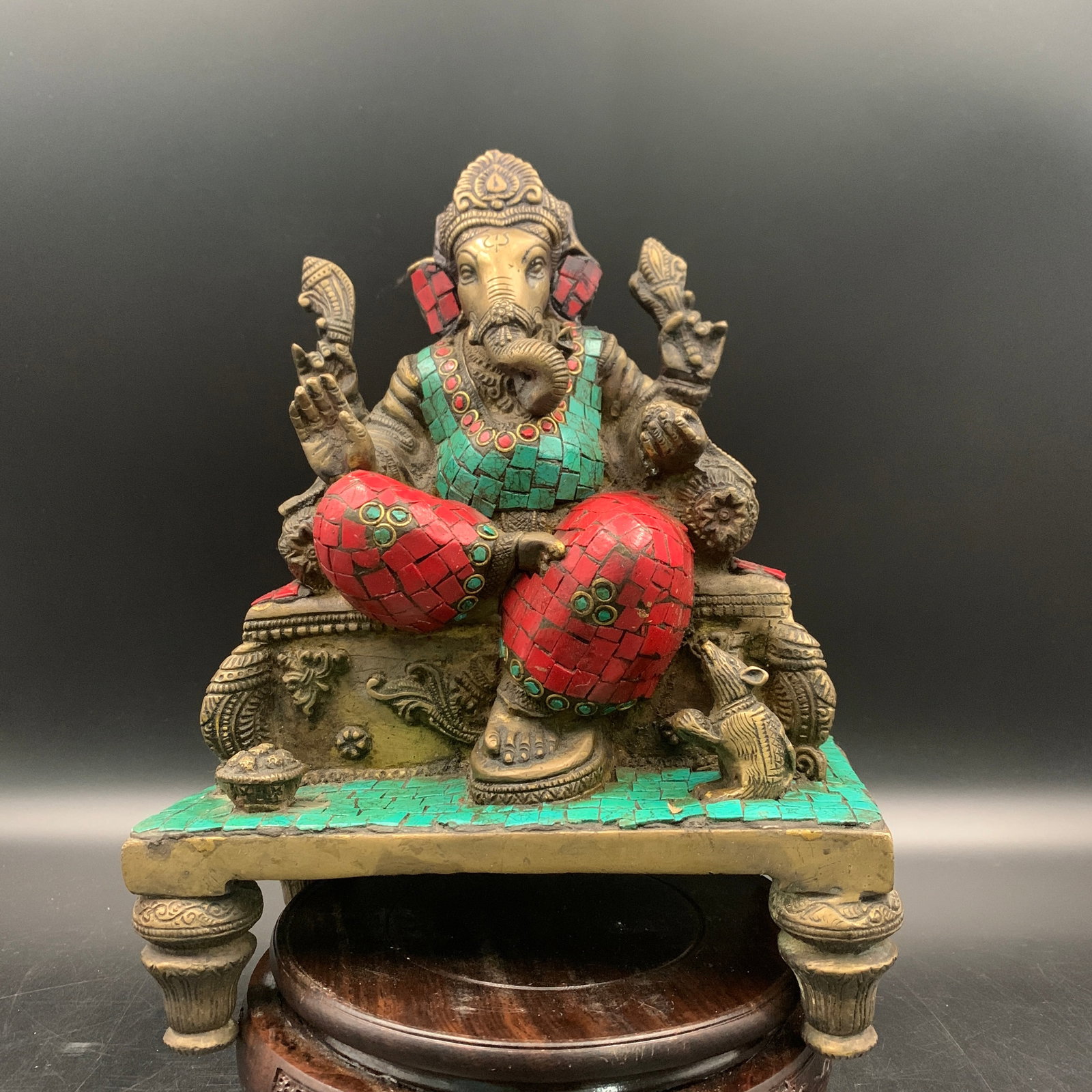RARE TIBETAN-STYLE TURQUOISE AND CORAL INLAID BRASS FIGURE OF GANESHA ON A THRONE: Qing Dynasty; Long: 7.4 inch; Width: 4.4 inch; High: 10 inch; Wooden base for diplay only