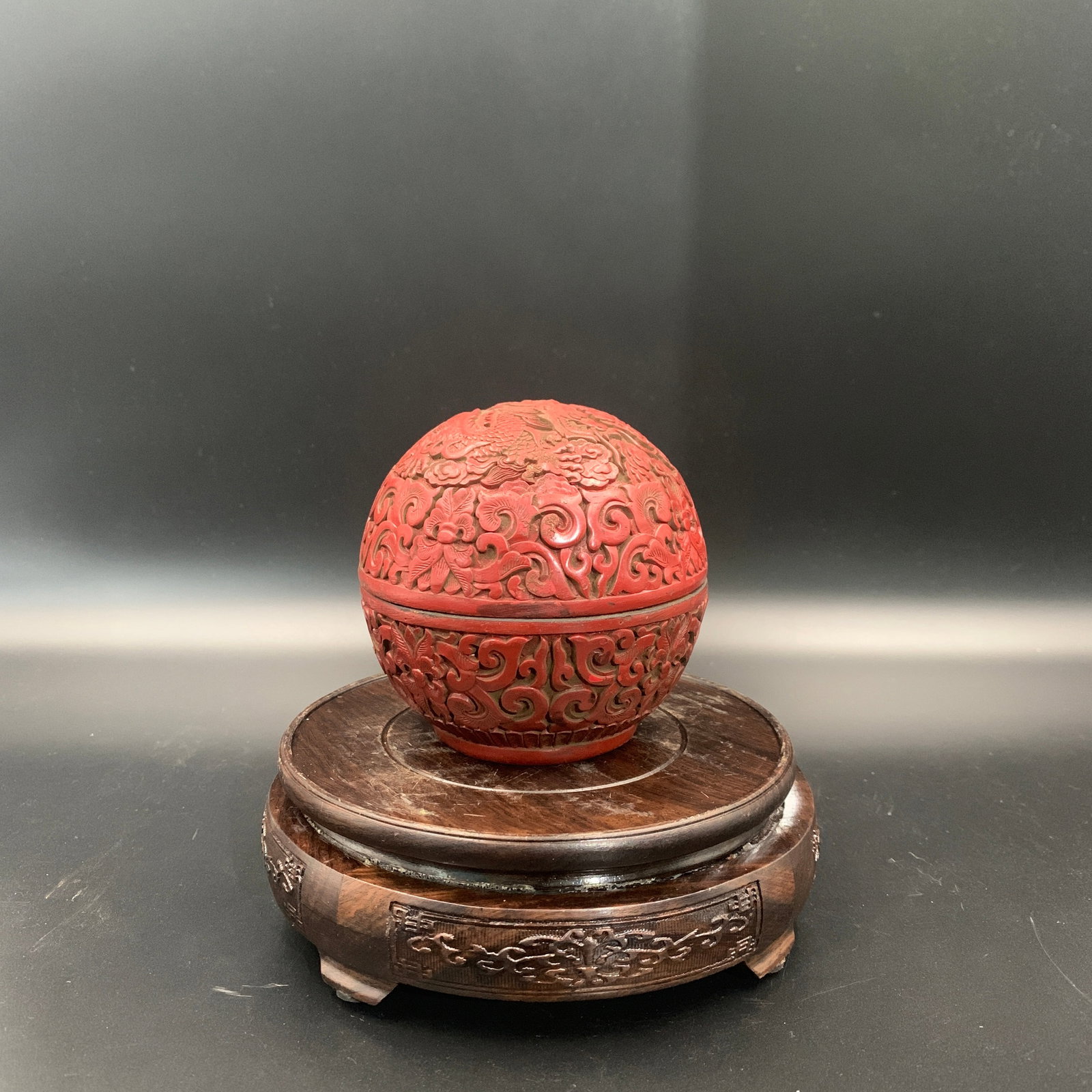 A CARVED CINNABAR LACQUER SPHERICAL BOX AND COVER
