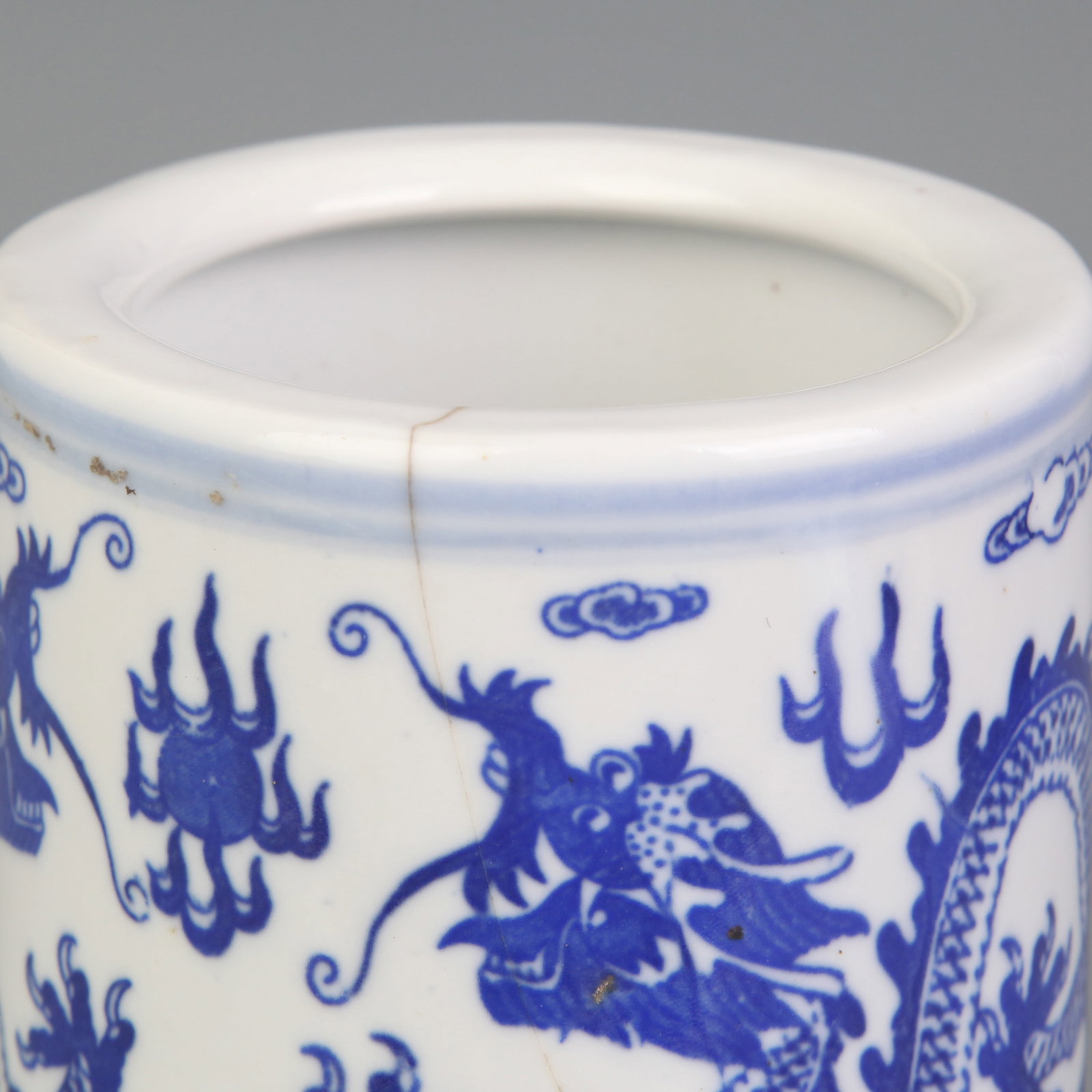 A BLUE-AND-WHITE ‘DRAGON’ PATTERN PORCELAIN BRUSH POT: Qing Dynasty Qian Long Period; Diameter: 3.5 inch; High: 4.6 inch; Wooden base for diplay only