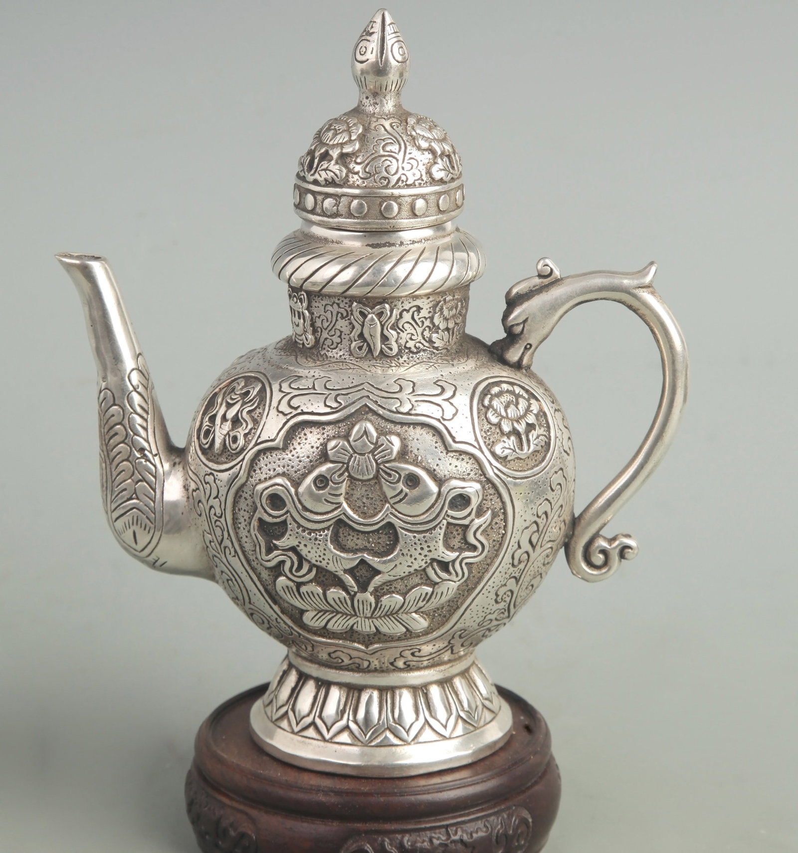 A FINELY CARVED TIBETAN PATTERN WHITE BRONZE EWER: Modern; High: 7.00 inch; High: 6.50 inch; Diameter: 2.80 inch; Wooden base for diplay only
