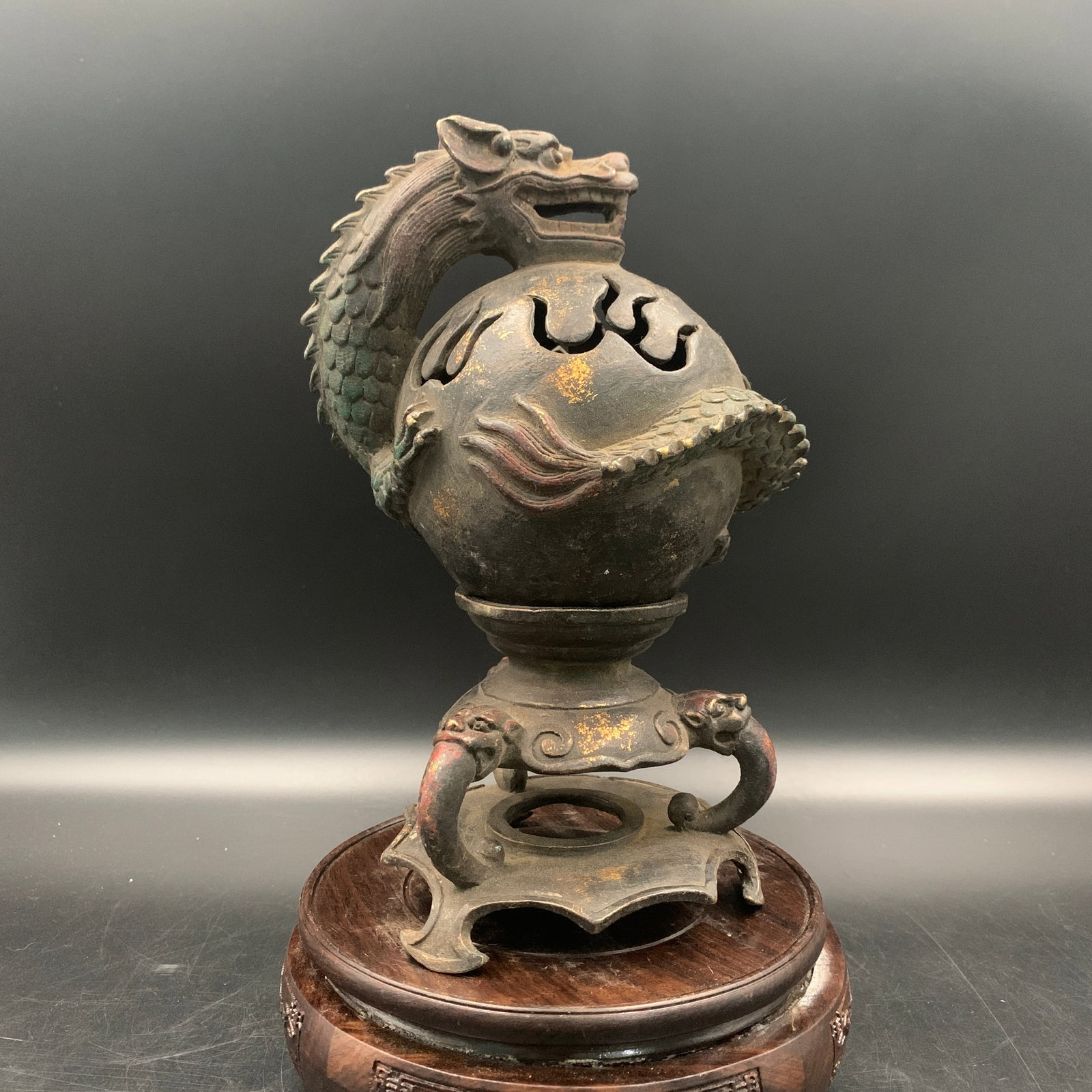 A PARCEL-GILT BRONZE 'DRAGON AND FLAMING PEARL' TRIPOD CENSER: Qing Dynasty; Long: 5 inch; Width: 5 inch; High: 8.3 inch; Wooden base for diplay only