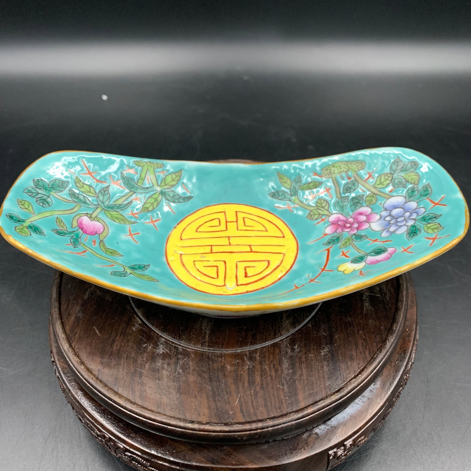 TURQUOISE-GROUND FAMILLE-ROSE 'SHOU' CURVED PORCELAIN DISH: Qing Dynasty; Long: 7.1 inch; Width: 3.5 inch; High: 1.4 inch; Wooden base for diplay only