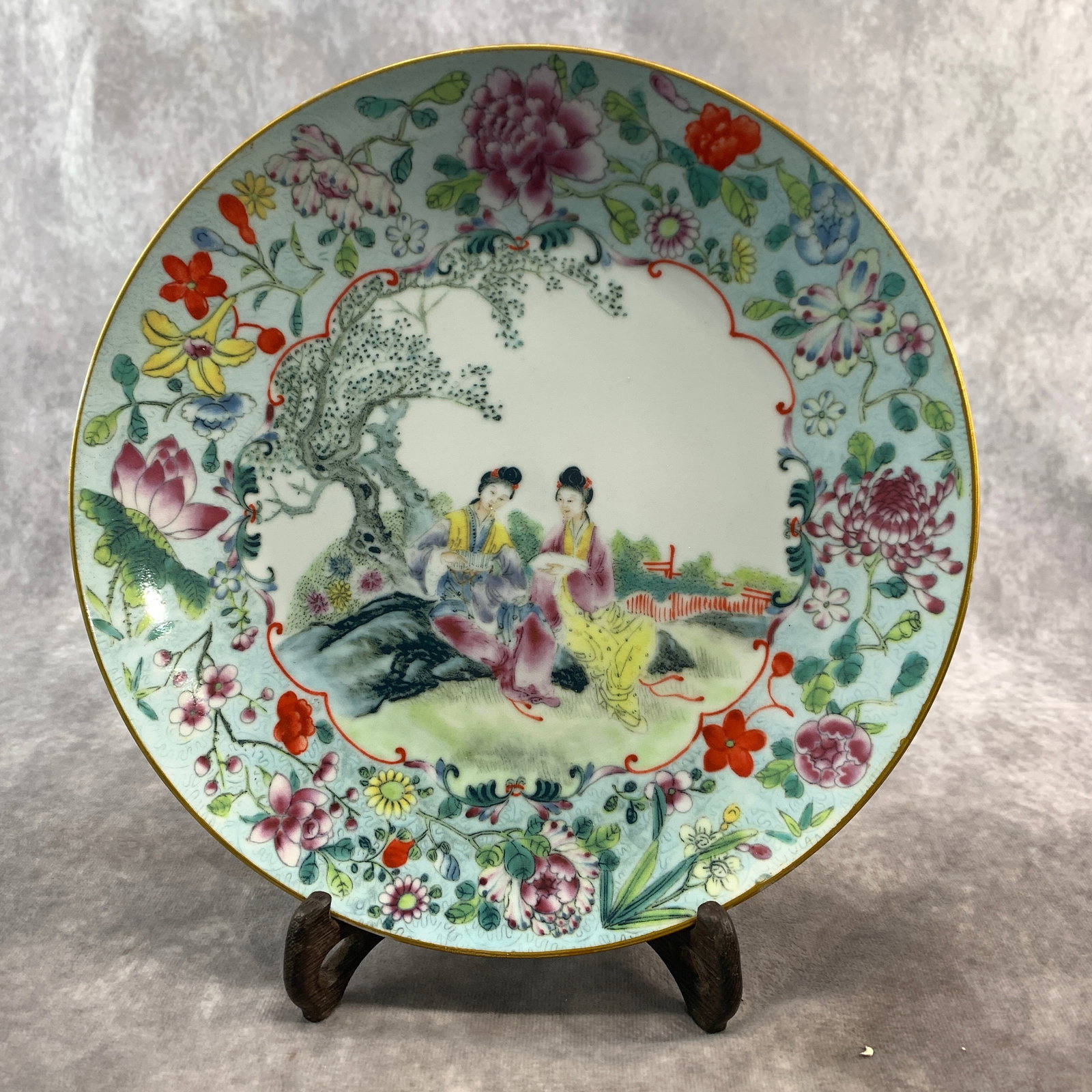 A FINE FAMILLE ROSE STORY PATTERN PORCELAIN PLATE: Qing Dynasty; High: 1.2 inch; Diameter: 10.2 inch; Wooden base for diplay only