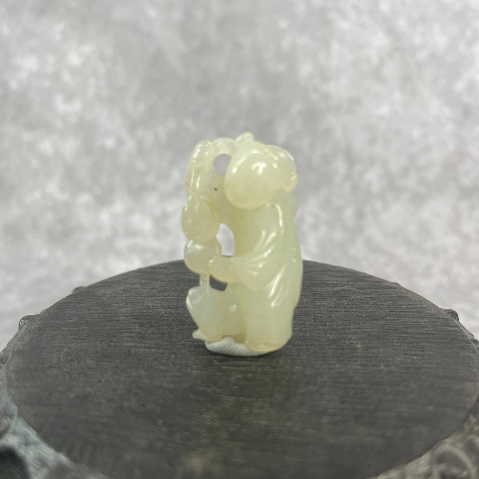 A FINE HETIAN JADE IN FIGURE OF BOY HOLDING A LINGZHI: Qing Dynasty; Long: 1.6 inch; Width: 0.91 inch; High: 0.51 inch