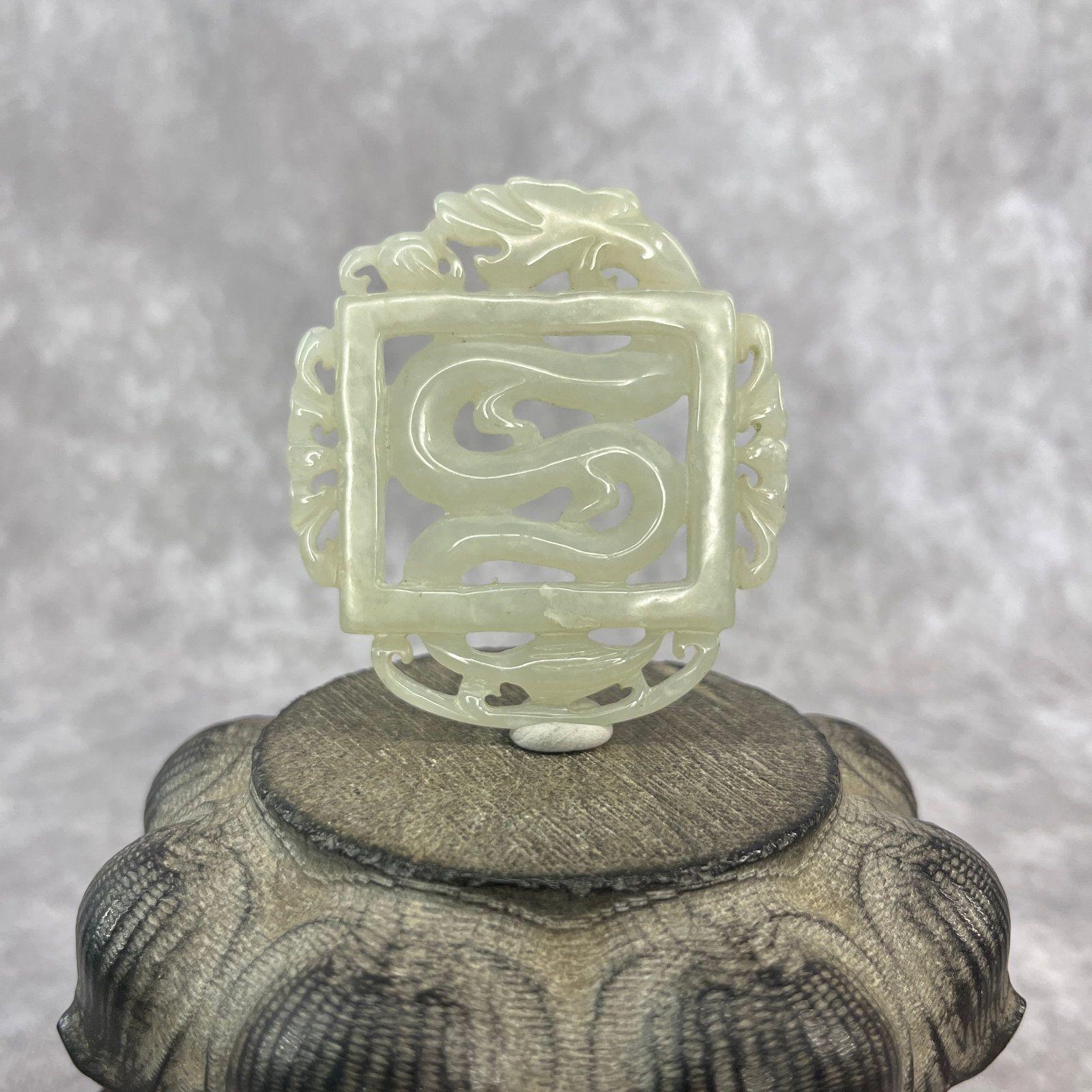A FINE HETIAN CELADON JADE IN FIGURE OF DRAGON: Qing Dynasty; Long: 2.7 inch; Width: 2.5 inch; High: 0.2 inch