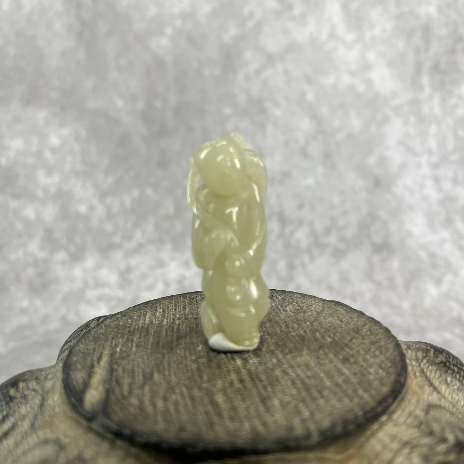 CARVED PALE CELADON JADE TOGGLE DEPICTING A BOY WITH LOTUS: Qing Dynasty; Long: 1.78 inch; Width: 0.67 inch; High: 0.51 inch