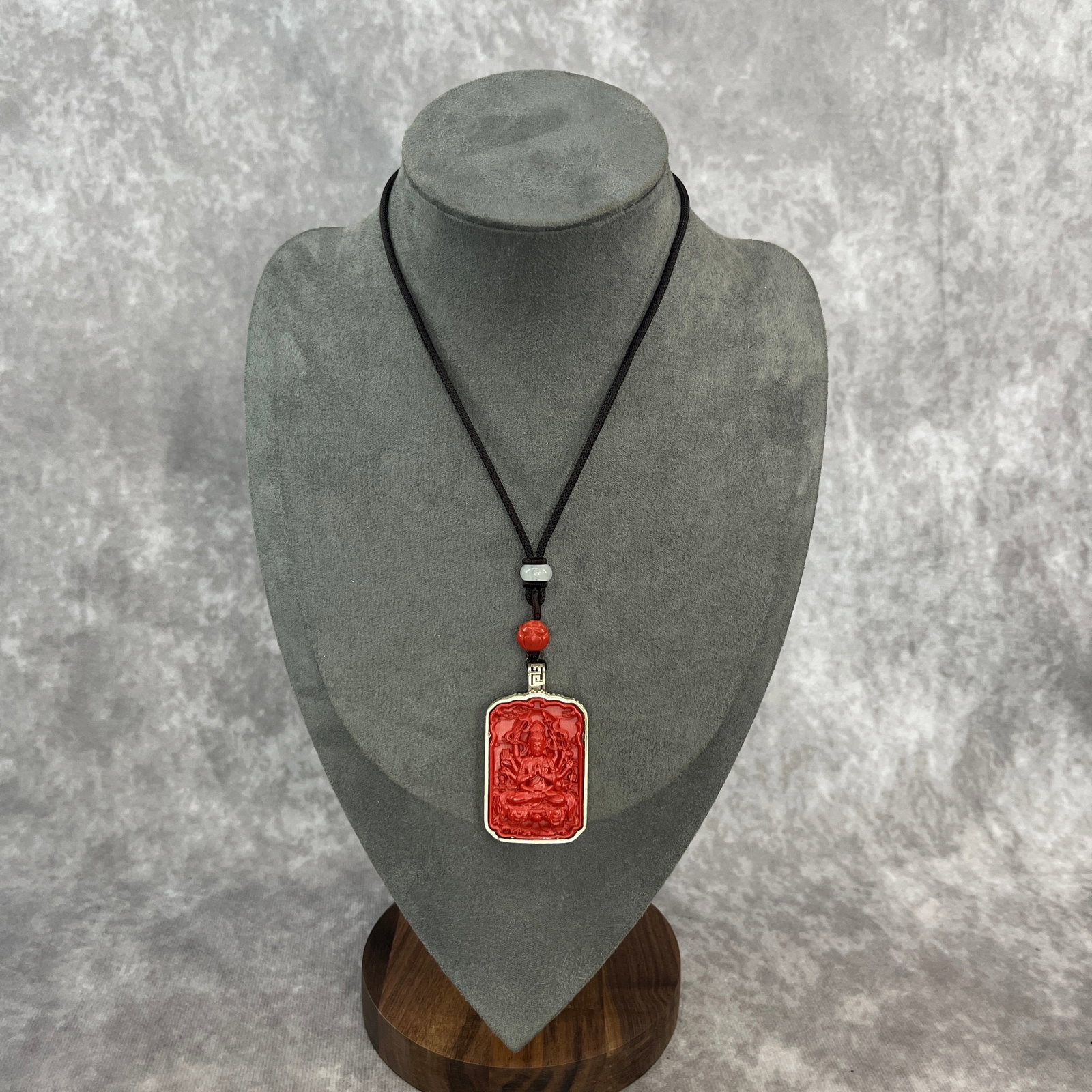 A FINELY CARVED CINNABAR LACQUER CUNDI BODHISATTVA NECKLACE