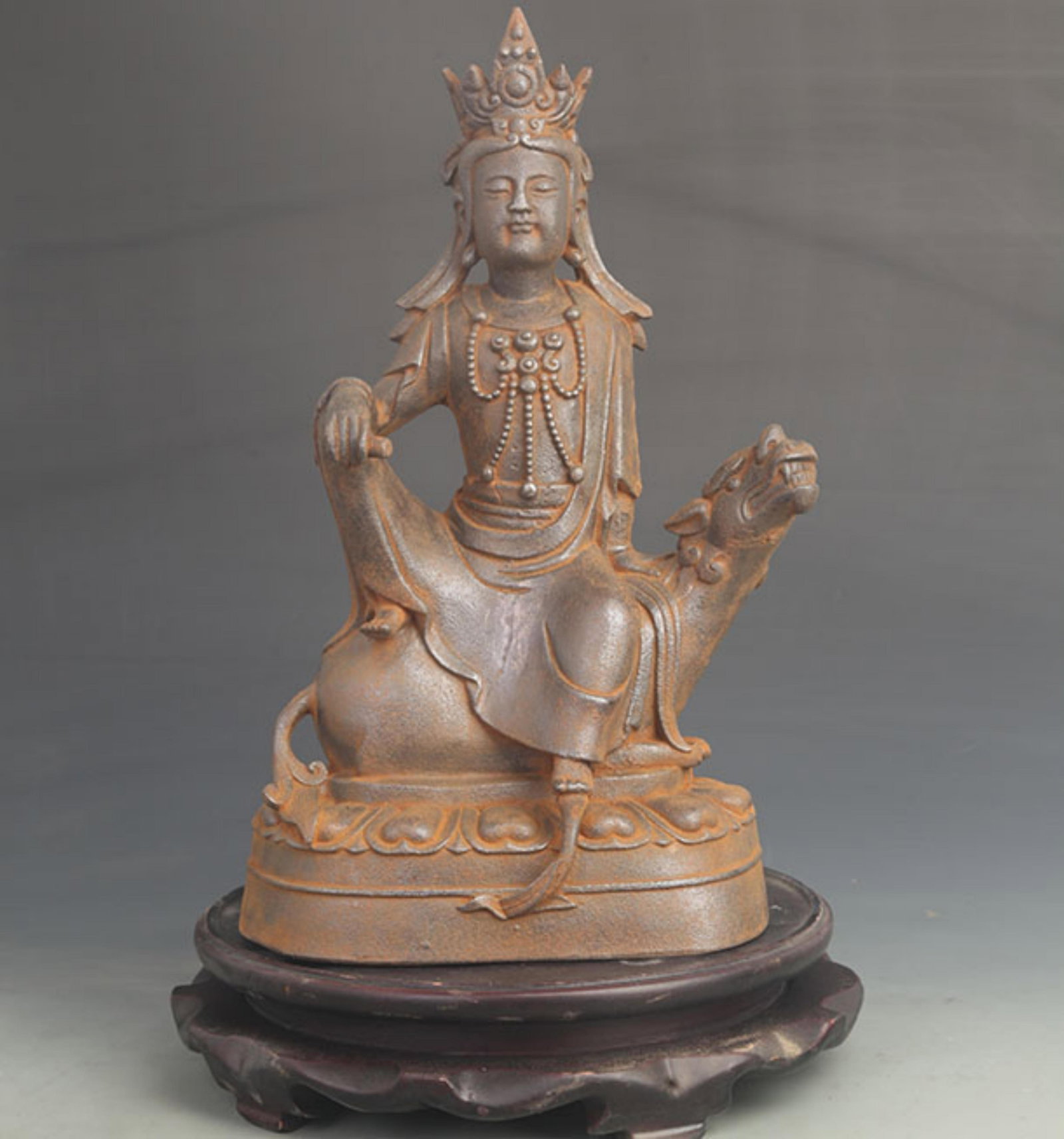 CAST IRON FIGURE OF SEATED SIMHANADA AVALOKITESHVARA: 19th Century; High: 15.0 inch; Width: 8.00 inch; Wooden base for diplay only