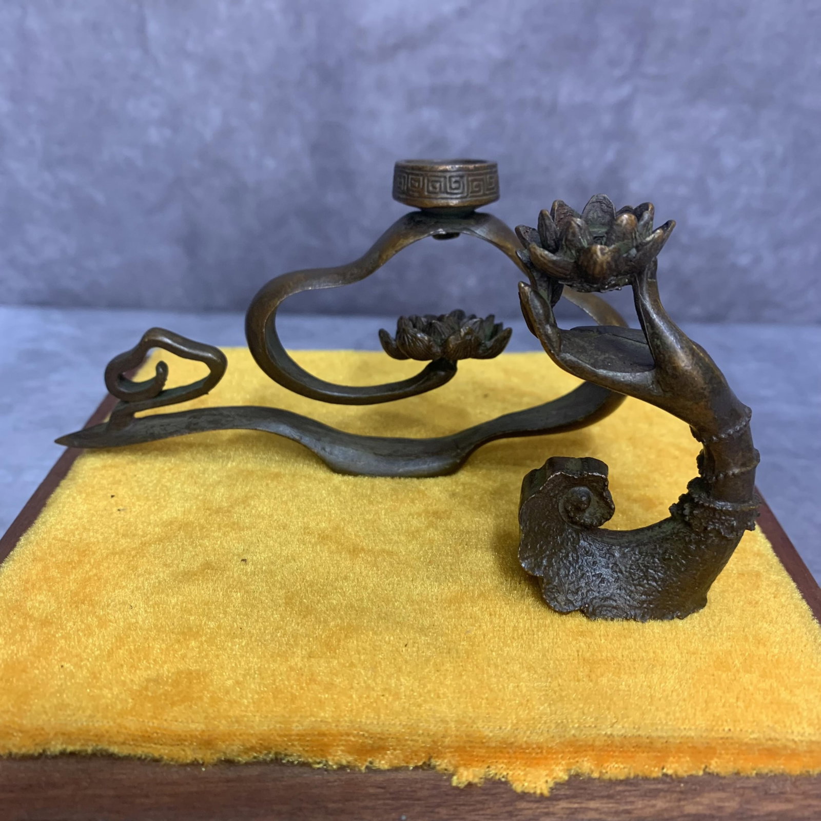 SET OF TWO SMALL BRONZE CANDLE HOLDER: Modern; High: 2.6 inch; Width: 5.0 inch. High: 2.7 inch; Width: 1.6 inch; Wooden base for diplay only