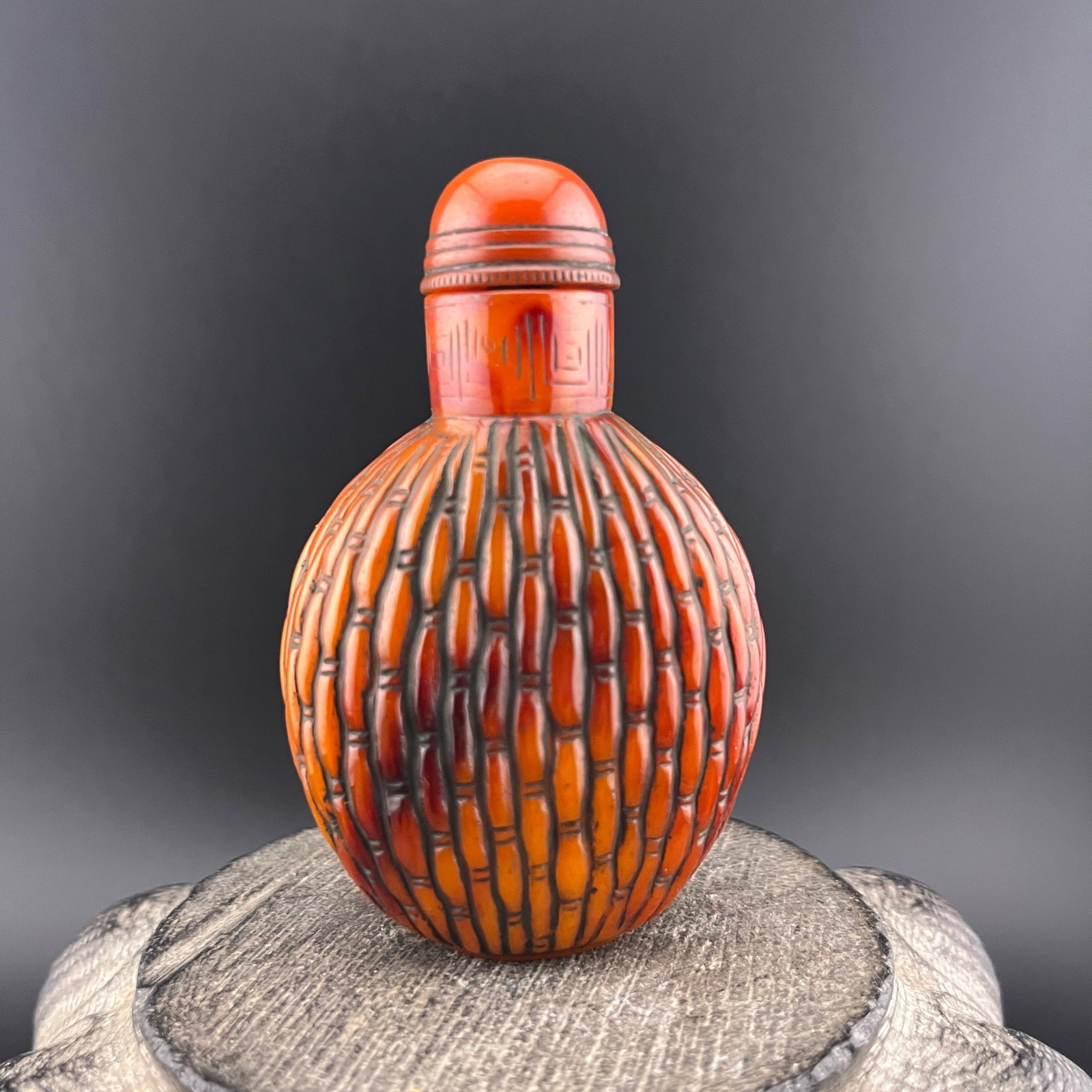 CARVED CINNABAR-STYLE SNUFF BOTTLE: Modern; Long: 1.8 inch; Width: 1.1 inch; High: 2.8 inch; Wooden base for diplay only