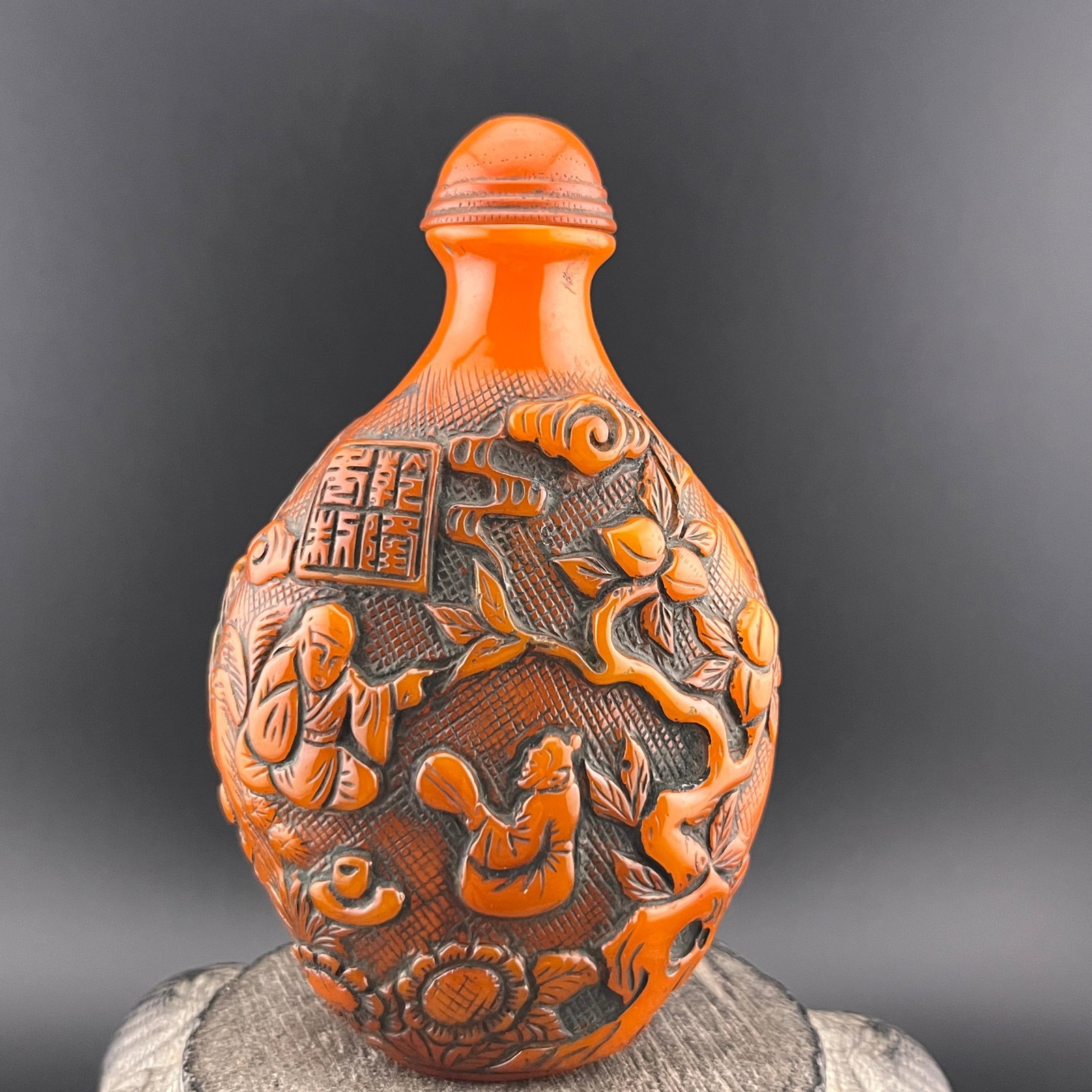 CARVED CINNABAR-STYLE SNUFF BOTTLE: Modern; Long: 2.5 inch; Width: 1.5 inch; High: 4 inch; Wooden base for diplay only