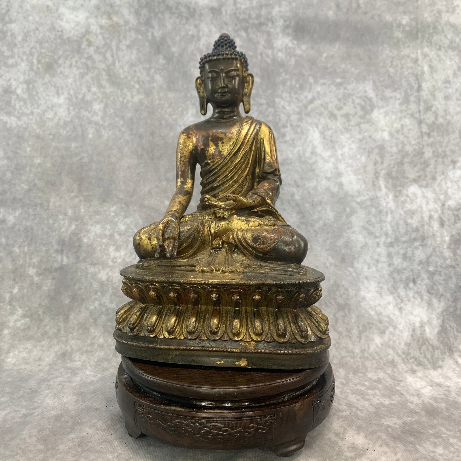 TIBETAN GILT BRONZE STATUE OF SHAKYAMUNI BUDDHA: Qing Dynasty; Long: 6.4 inch; Width: 4.2 inch; High: 9.7 inch; Wooden base for diplay only