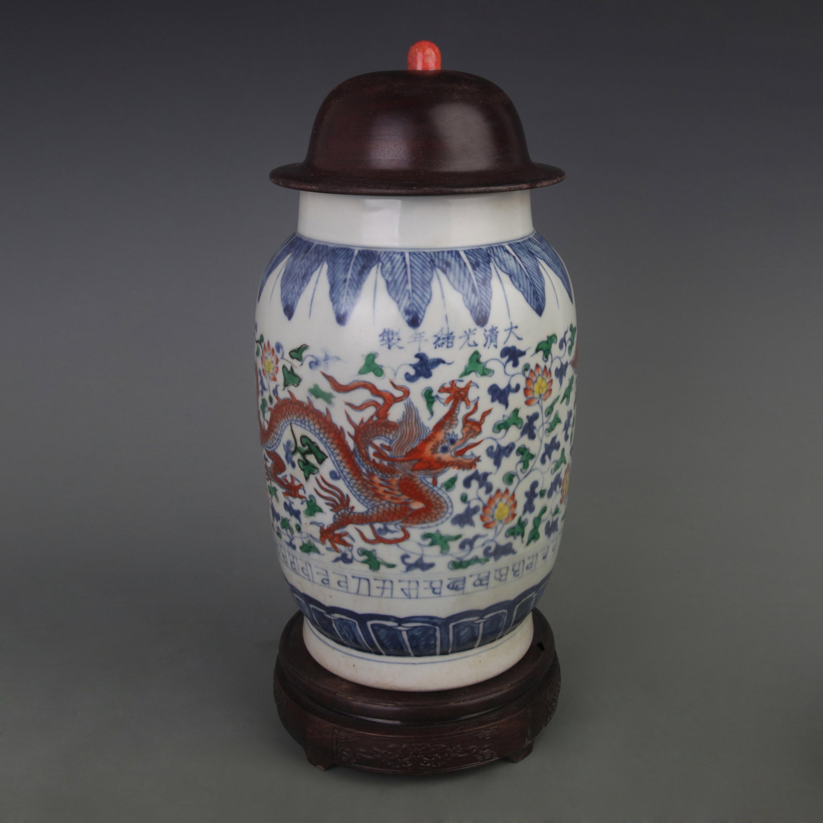 DOUCAI FLORAL DRAGON PATTERN GENERAL STYLE PORCELAIN JAR (WITH RED WOOD LID AND CORAL KNOB): Qing Dynasty; Diameter: 6.4 inch; High: 13.5 inch. Wooden base for display only