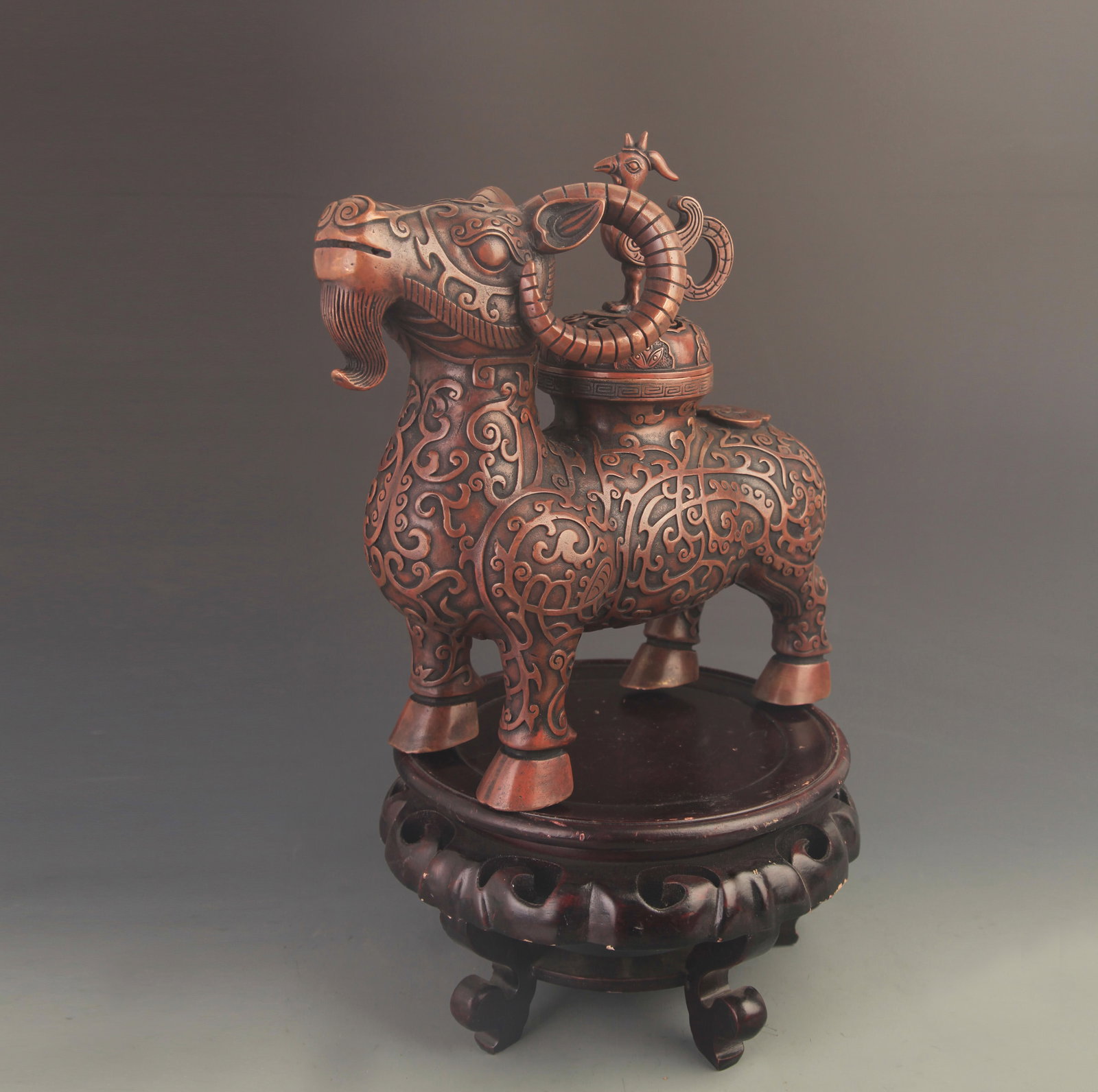 RARE BRONZE INCENSE BURNER WITH AUSPICIOUS GOAT AND PHOENIX KNOB: 20th Century; High: 11.5 inch; Width: 10.5 inch. Wooden base for display only