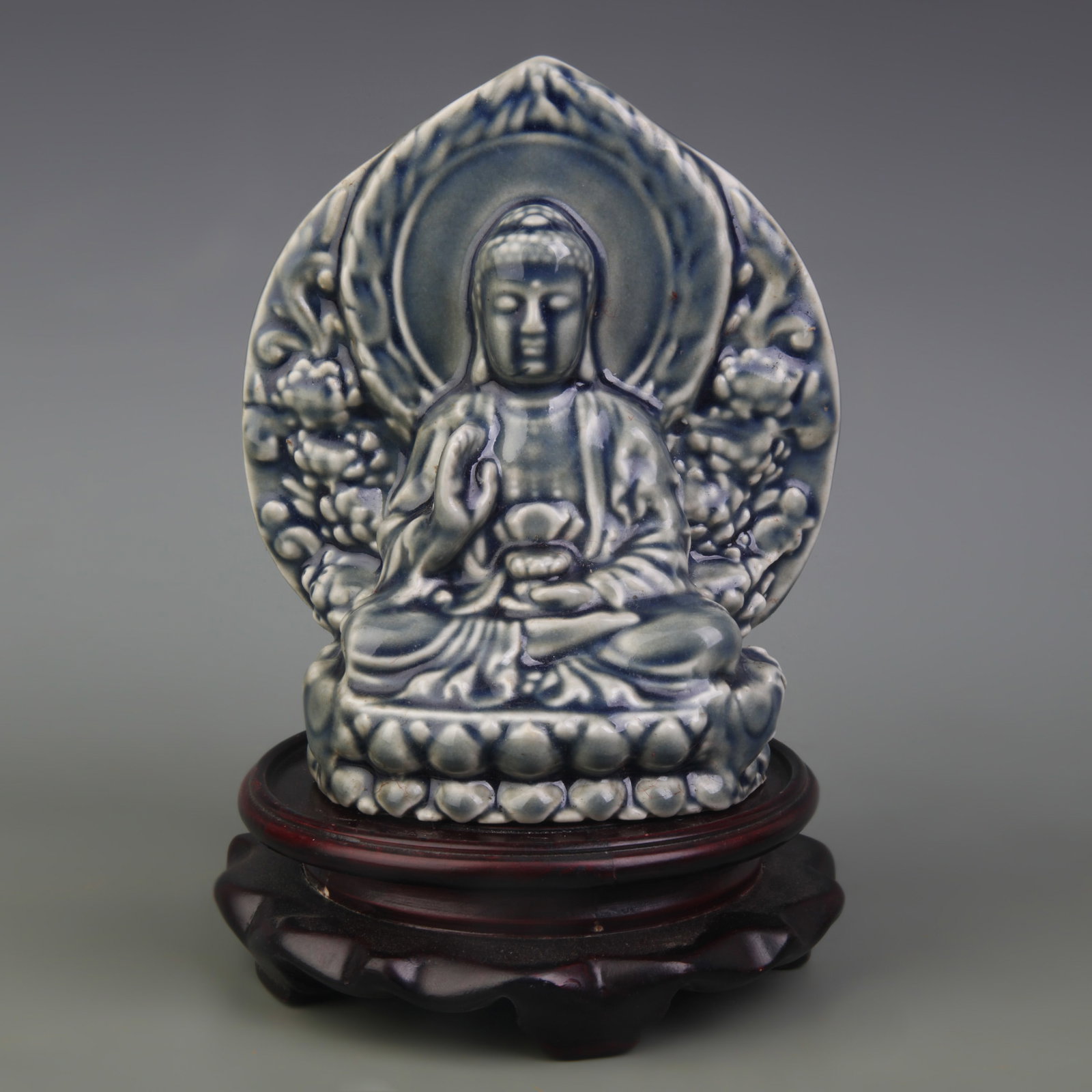 A MONOCHROME-GLAZED FIGURE OF SHAKYAMUNI BUDDHA: Qing Dynasty; High: 5.8 inch. Wooden base for display only