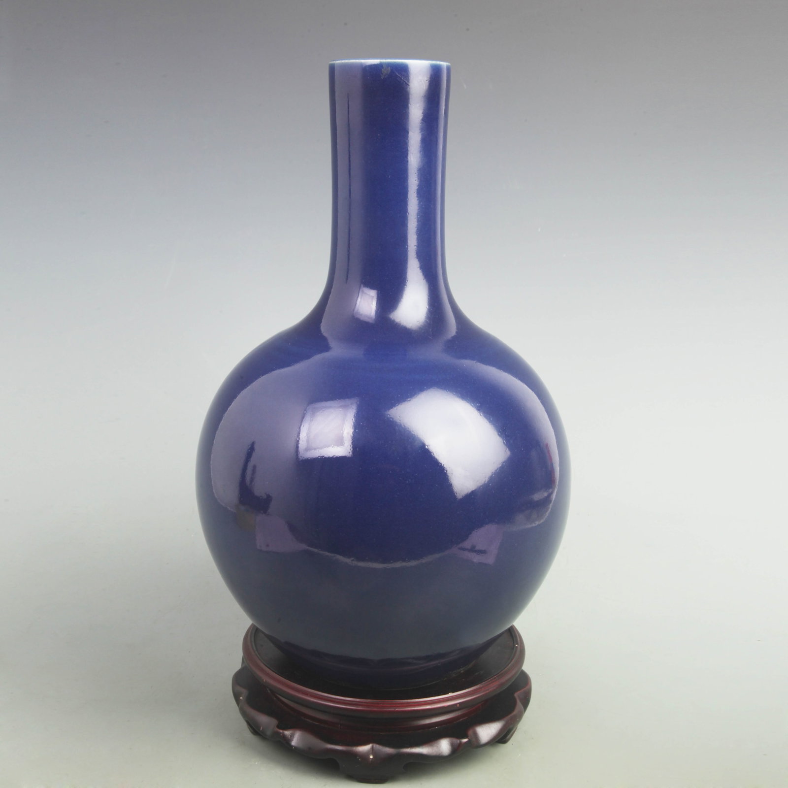 A DARK BLUE COLOR GLAZED MOON PORCELAIN BOTTLE: Qing Dynasty; High: 15 inch; Width: 9 inch; . Wooden base for display only