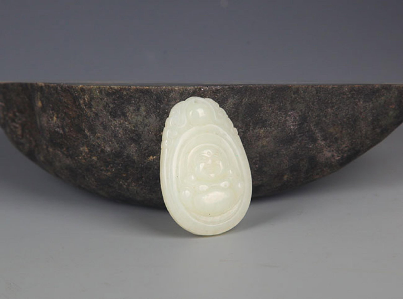 A FINELY CARVED HETIAN PALE CELADON JADE PENDANT PENDANT: Modern; High: 1.5 inch; Width: 1.0 inch; . Wooden base for display only