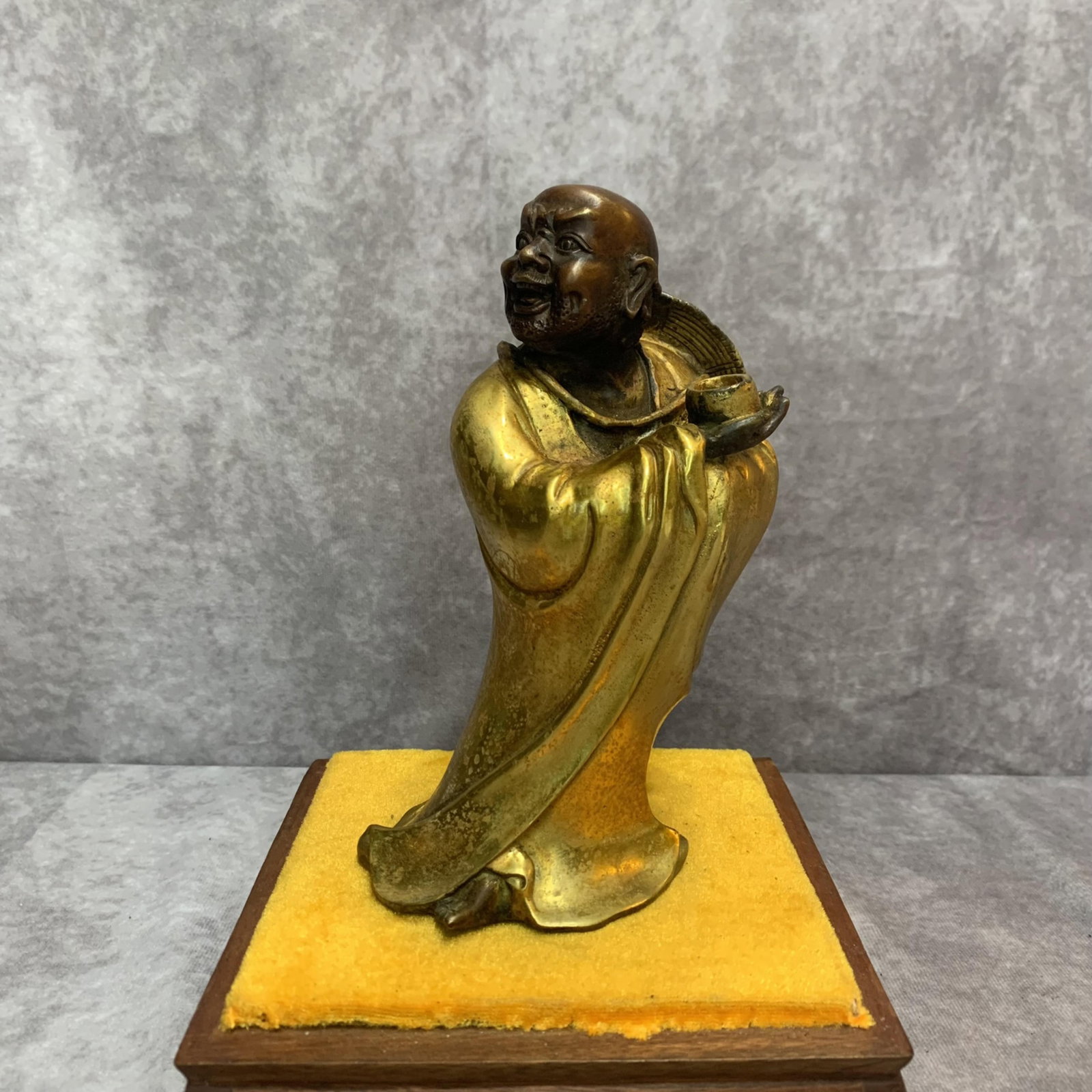 A FINE BRONZE LU HAN STATUE: 20th Century; High: 7.3 inch; Width: 3.6 inch; Long: 3.0 inch. Wooden base for display only