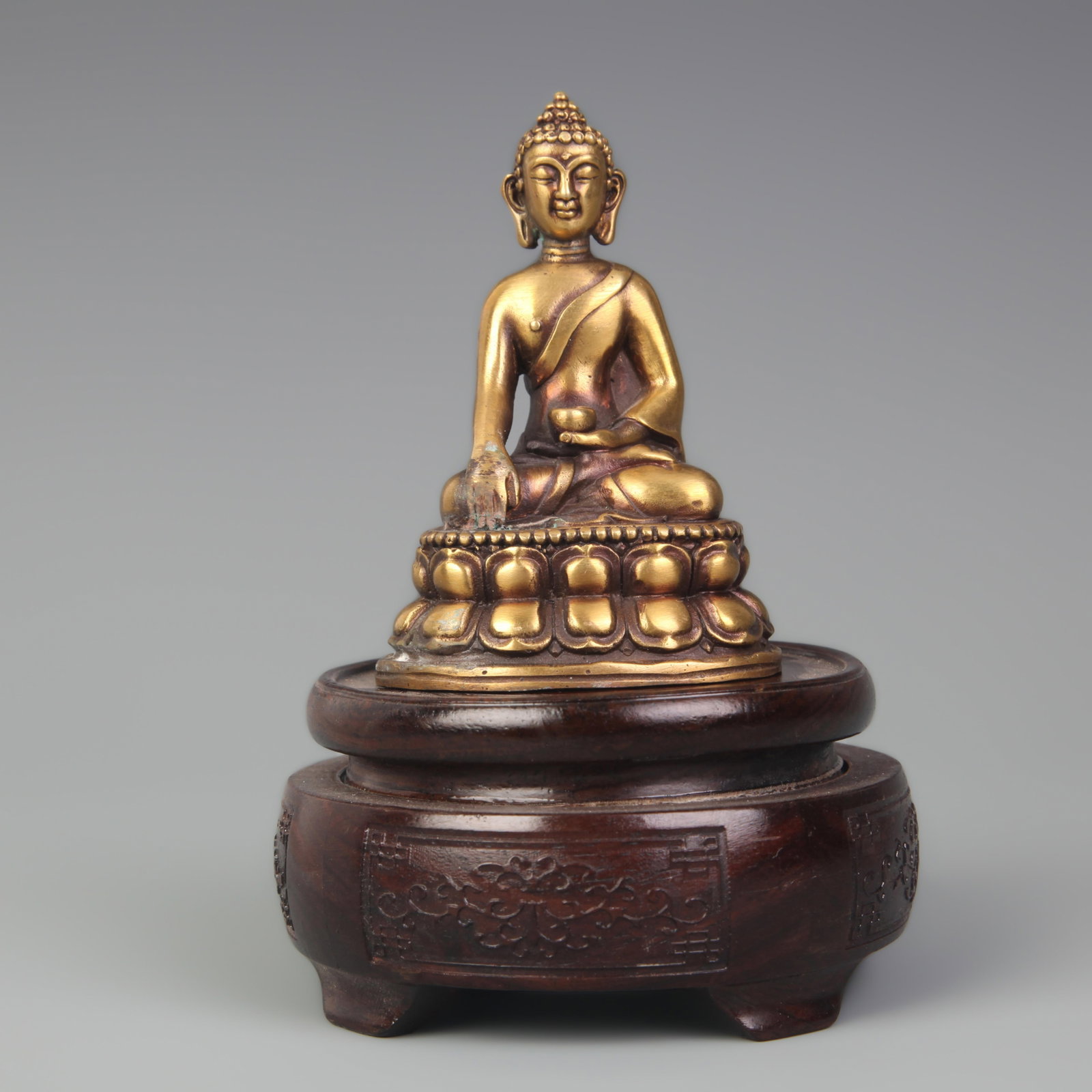 A TIBETAN-STYLE BRONZE SAKYAMUNI BUDDHA FIGURE: 19th Century; High: 3.75 inch; Width: 2.50 inch; wooden base for picture and display purpose only.