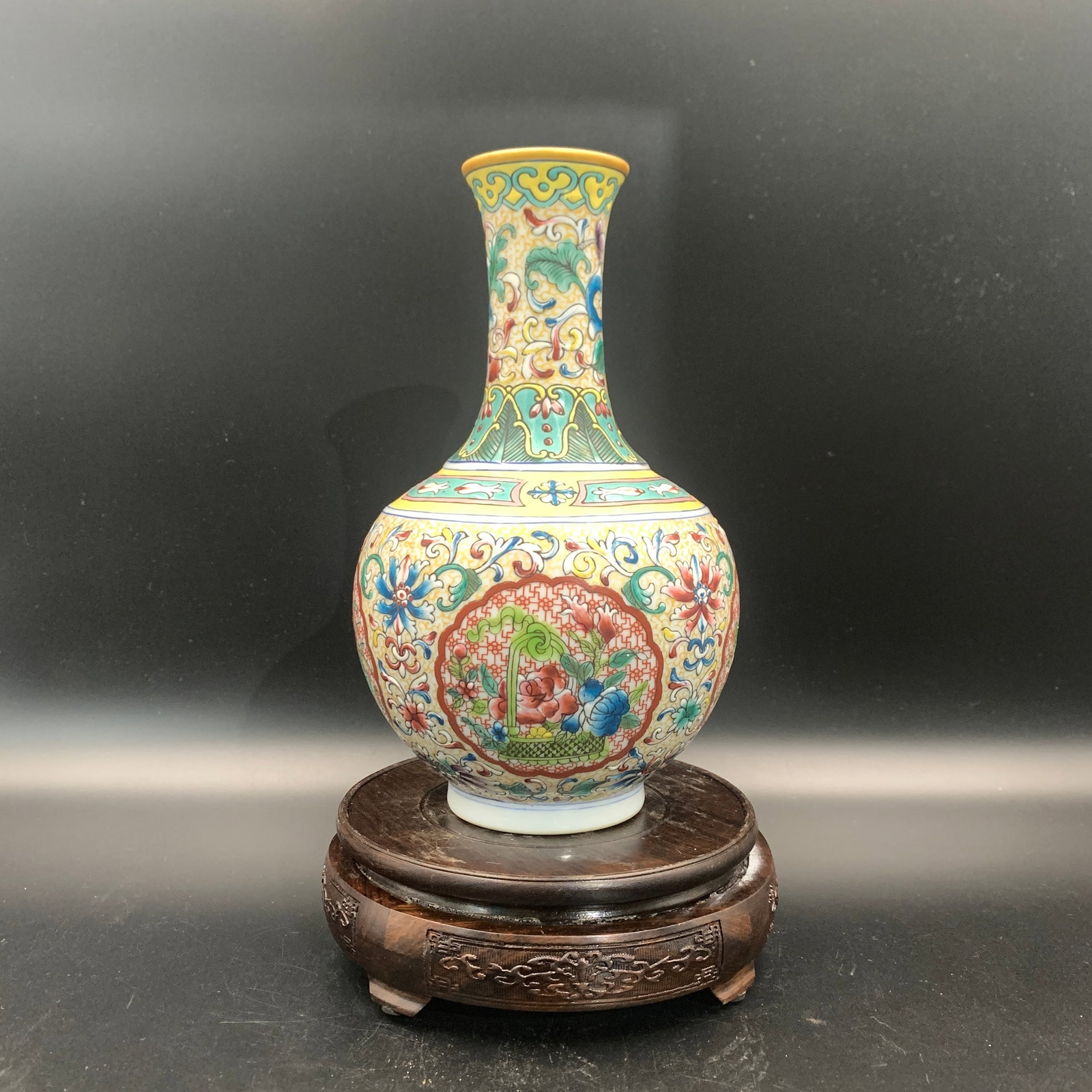 FAMILLE ROSE YELLOW-GROUND FLOWER BASKET BOTTLE PORCELAIN VASE: Qing Dynasty; High: 9.1 inch; Diameter: 5.6 inch; wooden base for picture and display purpose only.