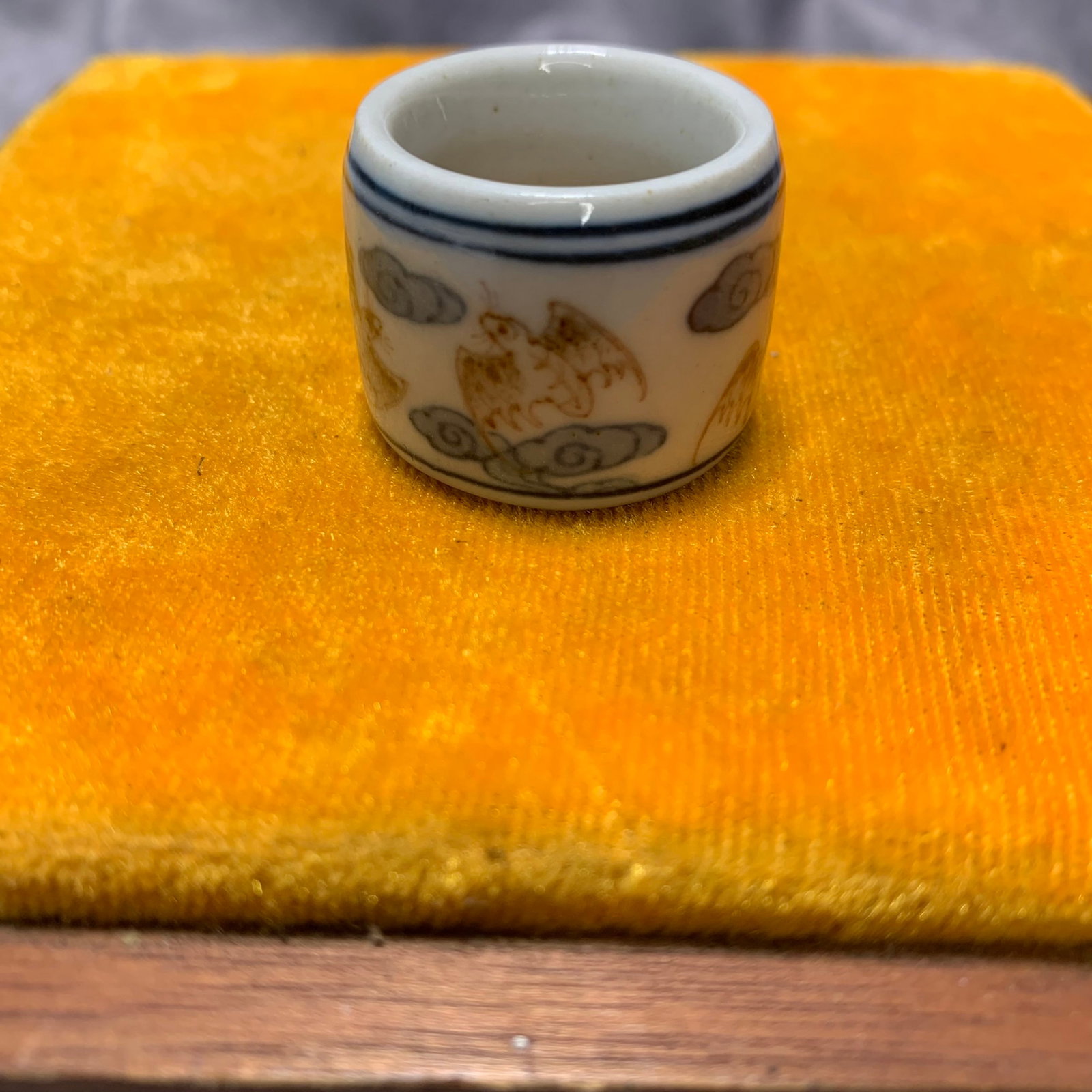 BLUE AND WHITE UNDERGLAZE RED GLAZED THUMB RING: Qing Dynasty; High: 0.9 inch; Diameter: 1.3 inch; wooden base for picture and display purpose only.