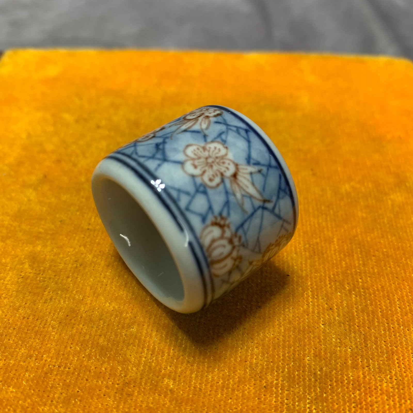 BLUE AND WHITE UNDERGLAZE RED GLAZED THUMB RING: Qing Dynasty; High: 0.9 inch; Diameter: 1.3 inch; wooden base for picture and display purpose only.