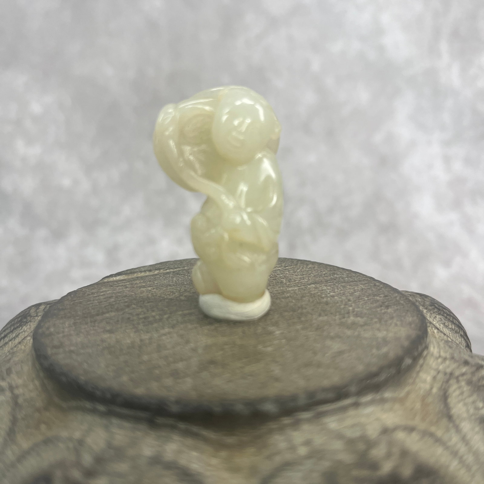 A FINE SMALL CARVED WHITE JADE IN FIGURE OF A BOY: Qing Dynasty; Long: 1.53 inch; Width: 0.98 inch; High: 0.61 inch; wooden base for picture and display purpose only.