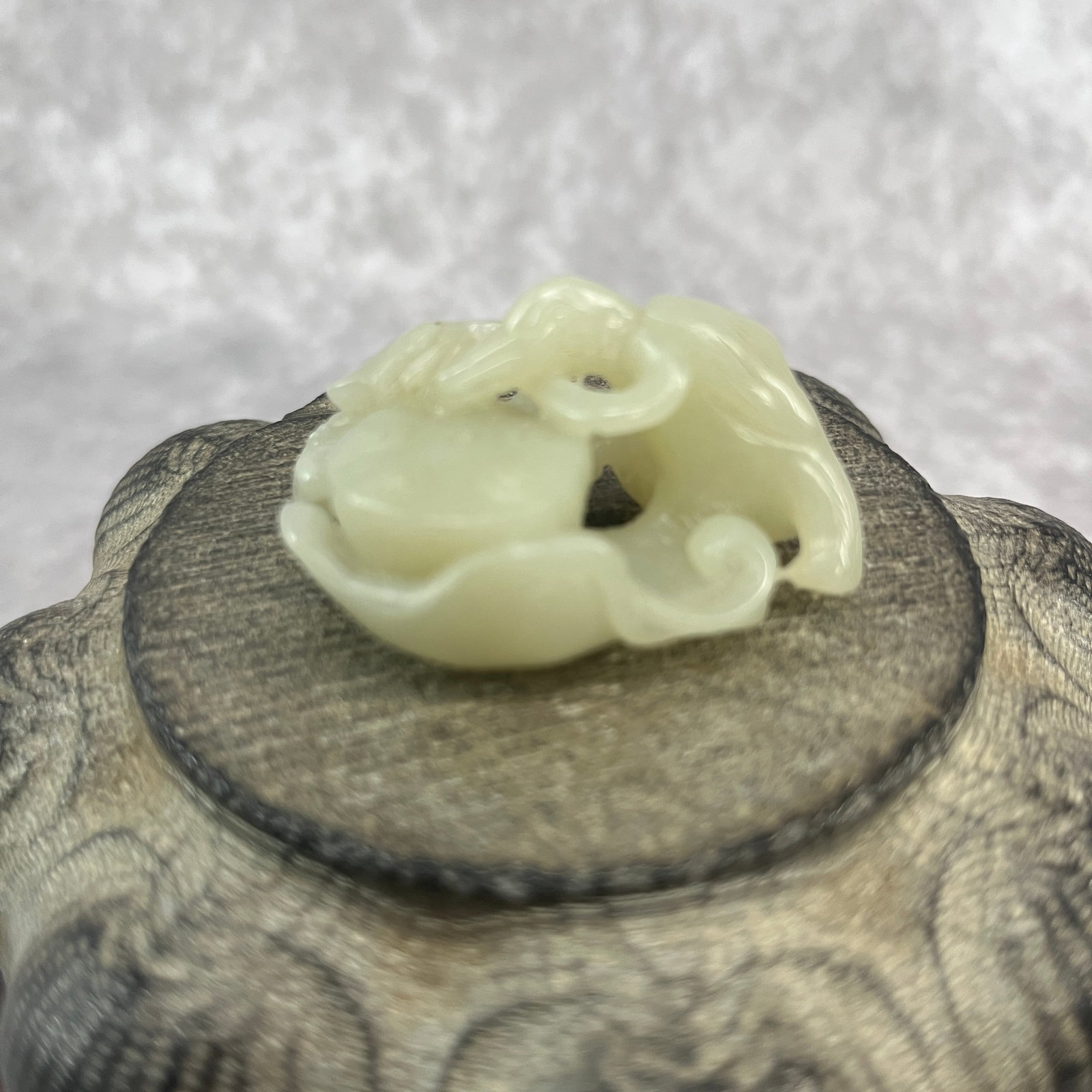 A CHINESE CARVED CELADON JADE OPENWORK BIRD AND LOTUS TOGGLE: Qing Dynasty; Long: 1.83 inch; Width:1.34 inch; High: 0.83 inch; wooden base for picture and display purpose only.