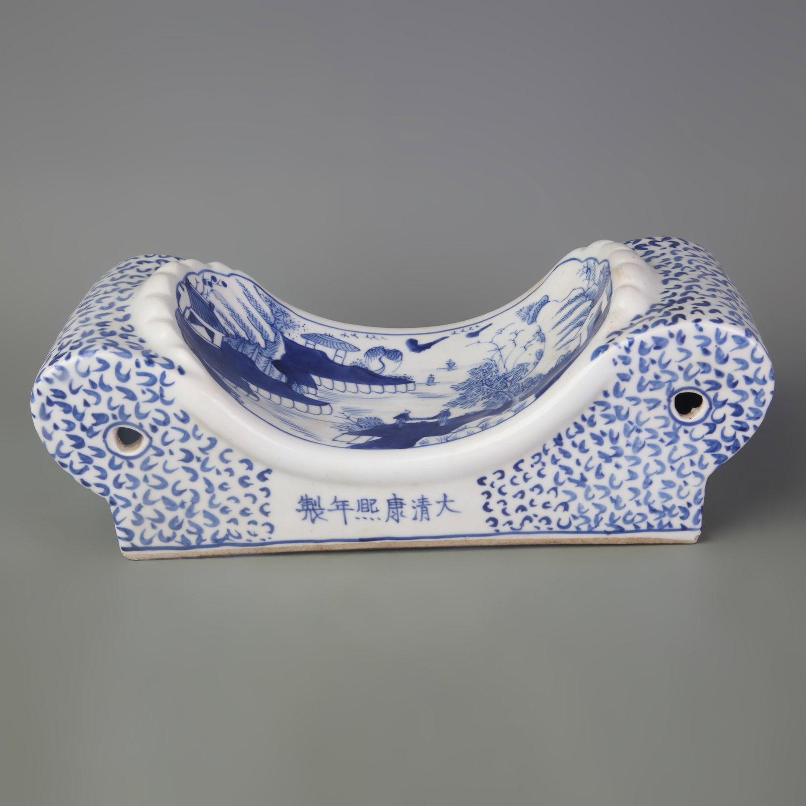 BLUE AND WHITE PORCELAIN PILLOW WITH LANDSCAPE DESIGN: Qing Dynasty Kang Xi Period; Long: 11.1 inch; High:4.1 inch; wooden base for picture and display purpose only.