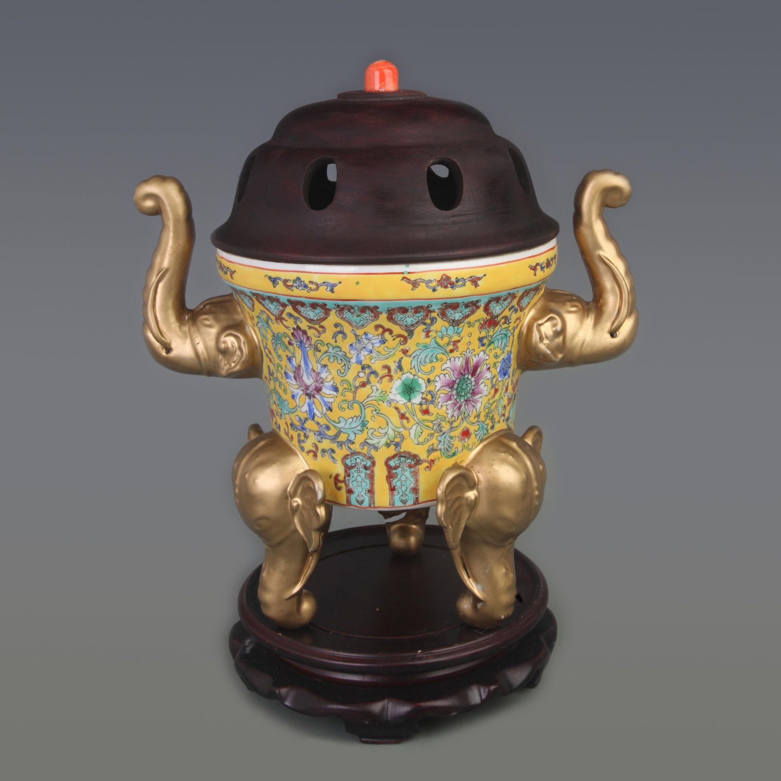 FAMILLE ROSE ENAMEL TRIPOD INCENSE BURNER WITH ELEPHANT HANDLES (ROSEWOOD COVER AND CORAL FINIAL): Qing Dynasty; Diameter:10.0 inch; High: 12.8 inch ; wooden base for picture and display purpose only.