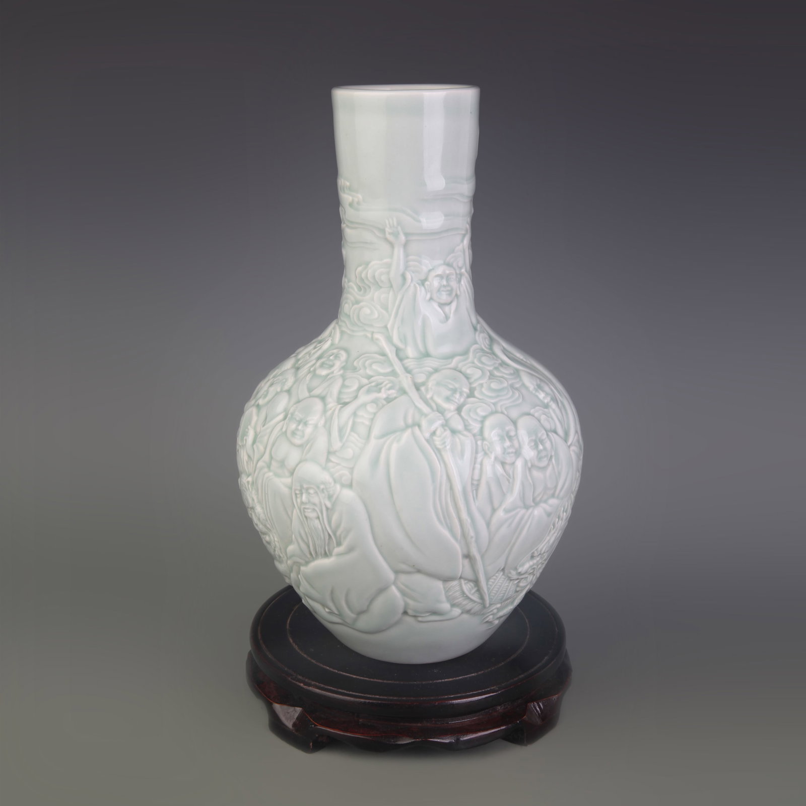 CELADON COLOR GLAZED CARVED FIGURE PATTERN PORCELAIN VASE: Qing Dynasty; Diameter: 3.4 inch; High: 11.1 inch; wooden base for picture and display purpose only.