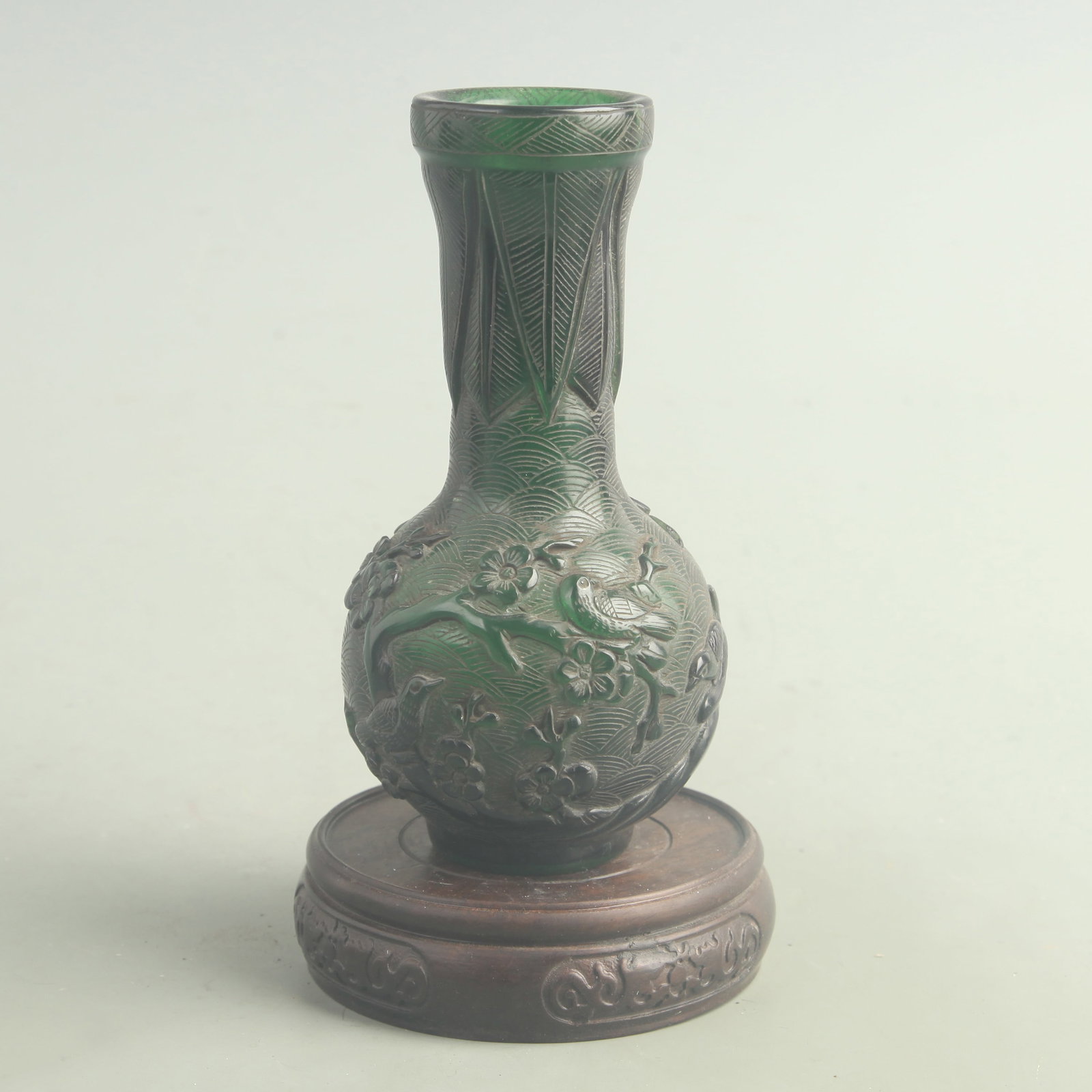 GREEN GLASS MADE PLUM BLOSSOM AND AUSPICIOUS BIRD VASE: Qing Dynasty; High: 5.80 inch; Diameter: 1.70 inch; wooden base for picture and display purpose only.