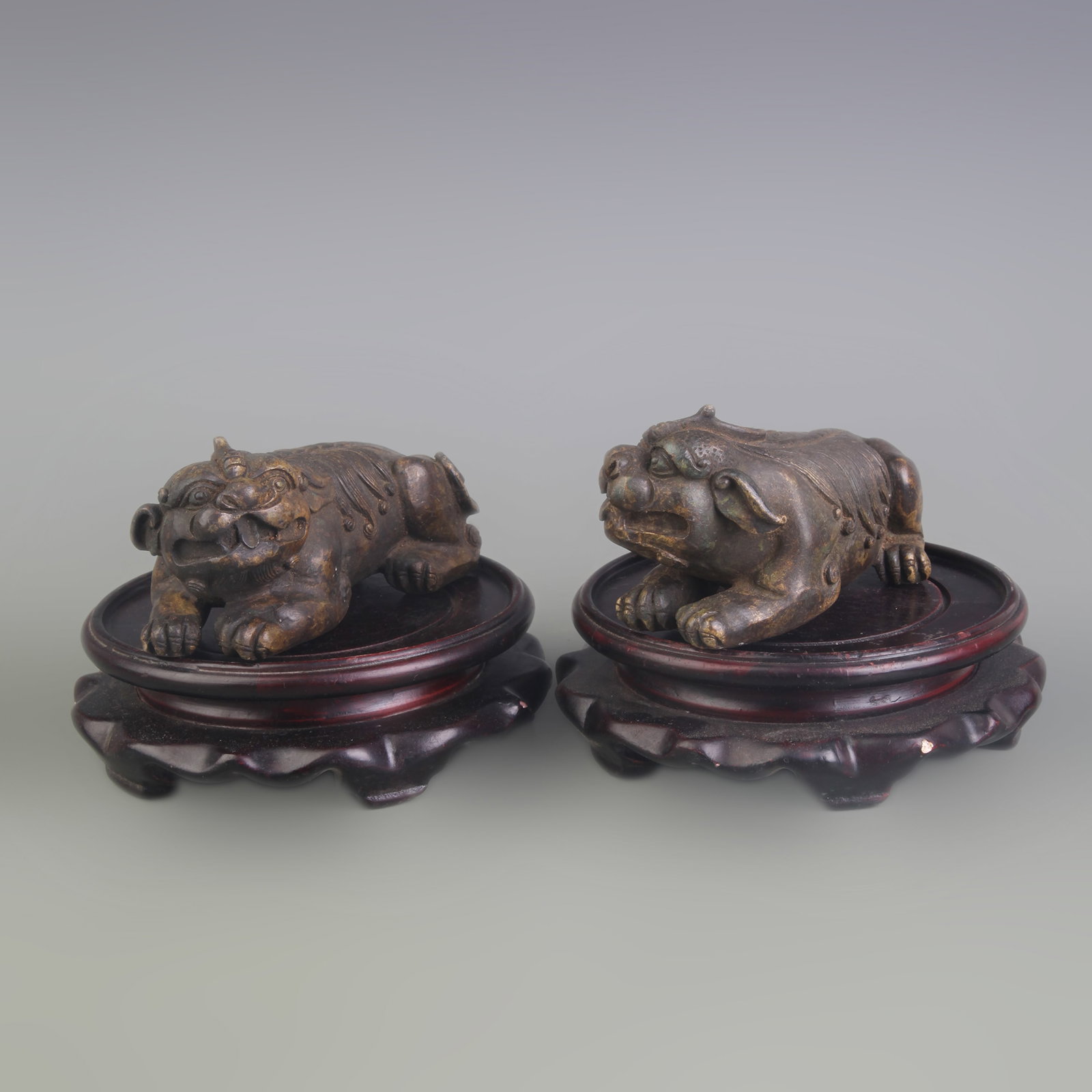 A PAIR OF BRONZE LION ORNAMENTS: Qing Dynasty; Long: 4.5 inch; High: 2.2 inch; wooden base for picture and display purpose only.