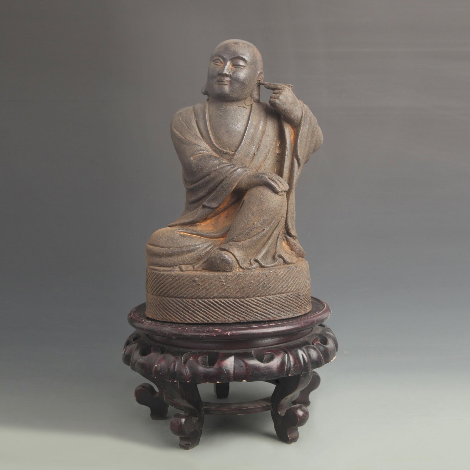 A FINE CAST IRON EAR-PICKING ARHAT STATUE: 20th Century; High: 11.75 inch; Width: 7.00 inch; wooden base for picture and display purpose only.